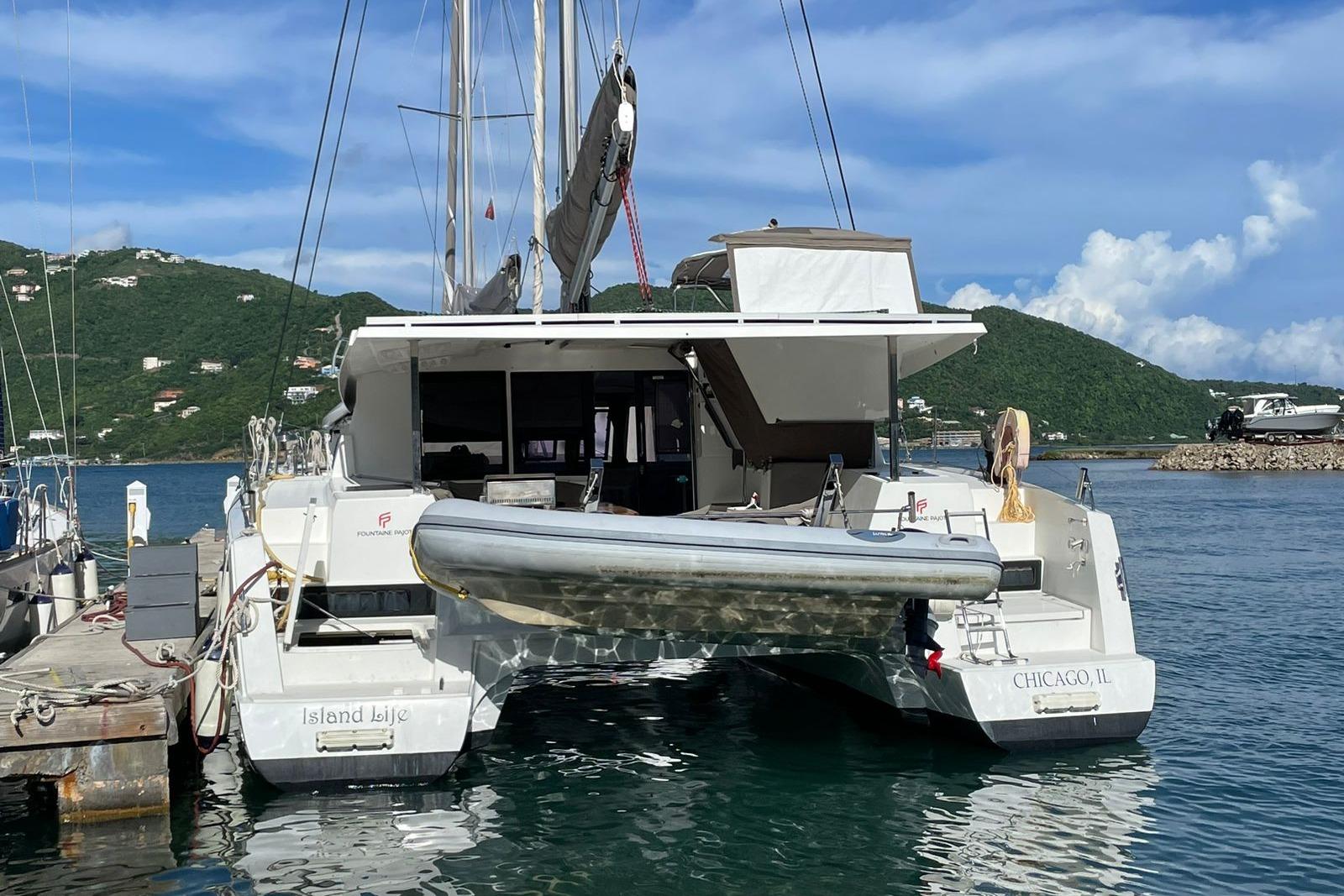 2017 Fountaine Pajot Lucia 40 catamaran docked in a scenic marina setting.