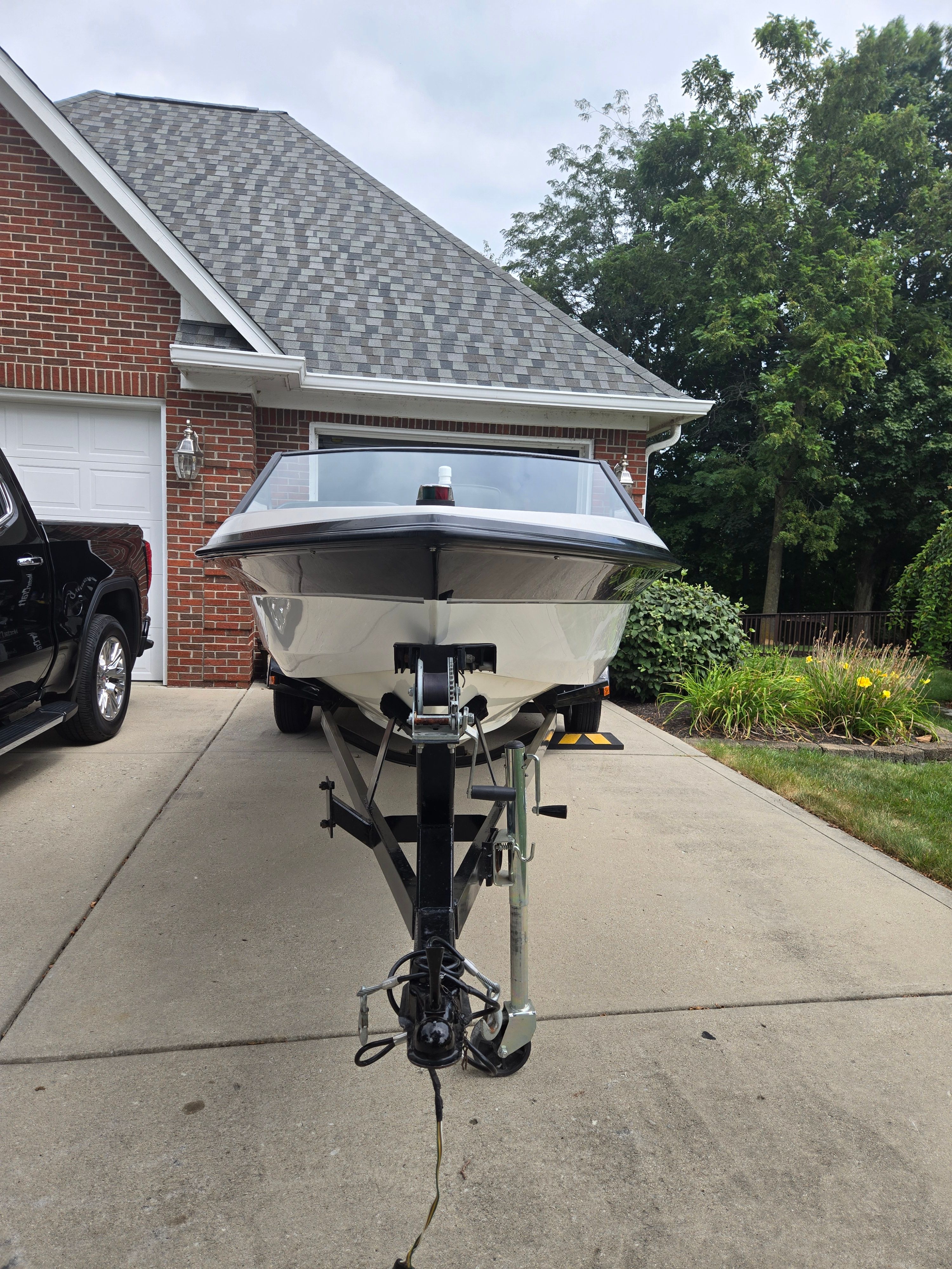 1991 MasterCraft Barefoot 200 boat on trailer in driveway.