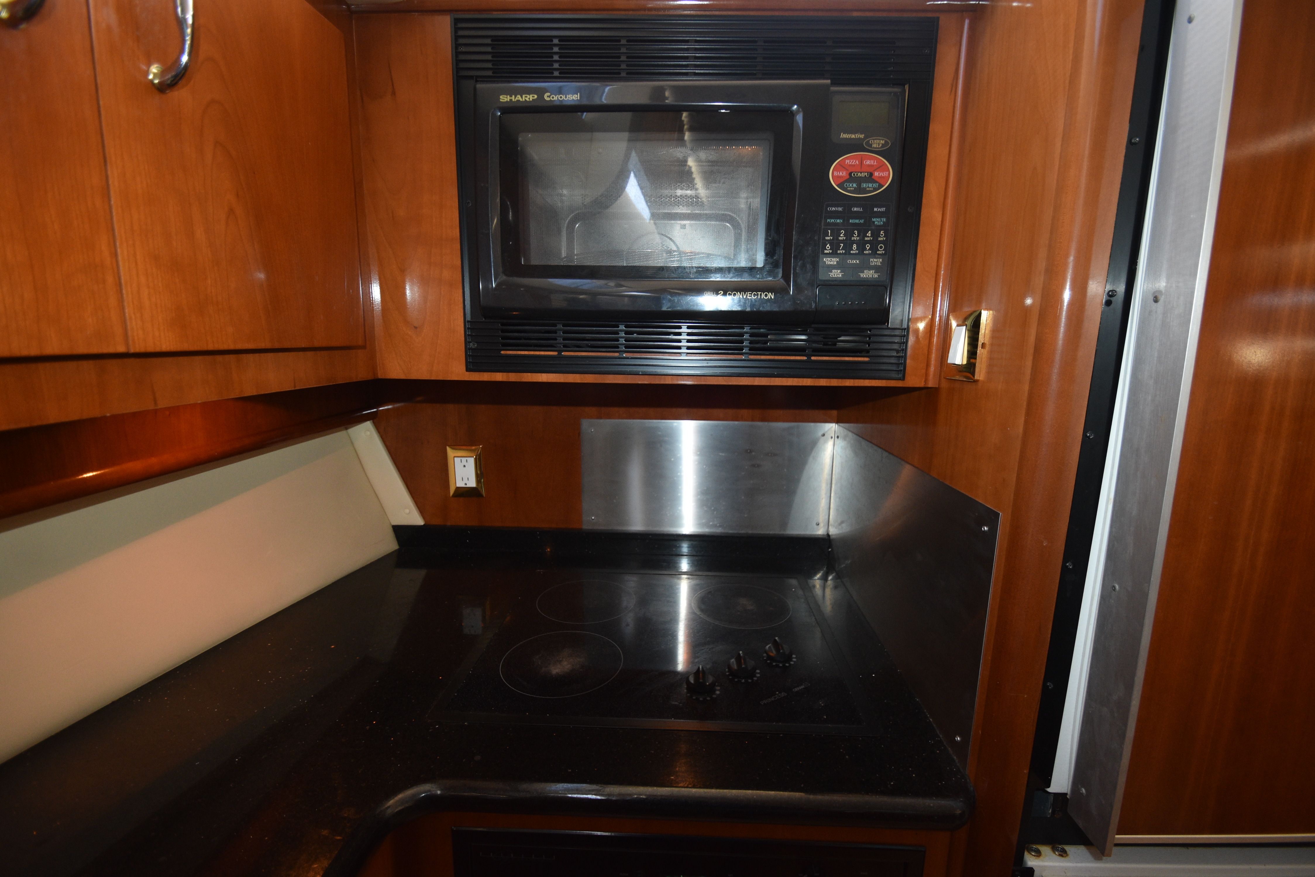 The galley of the 2004 Carver 466 Motor Yacht features a microwave and a stovetop.