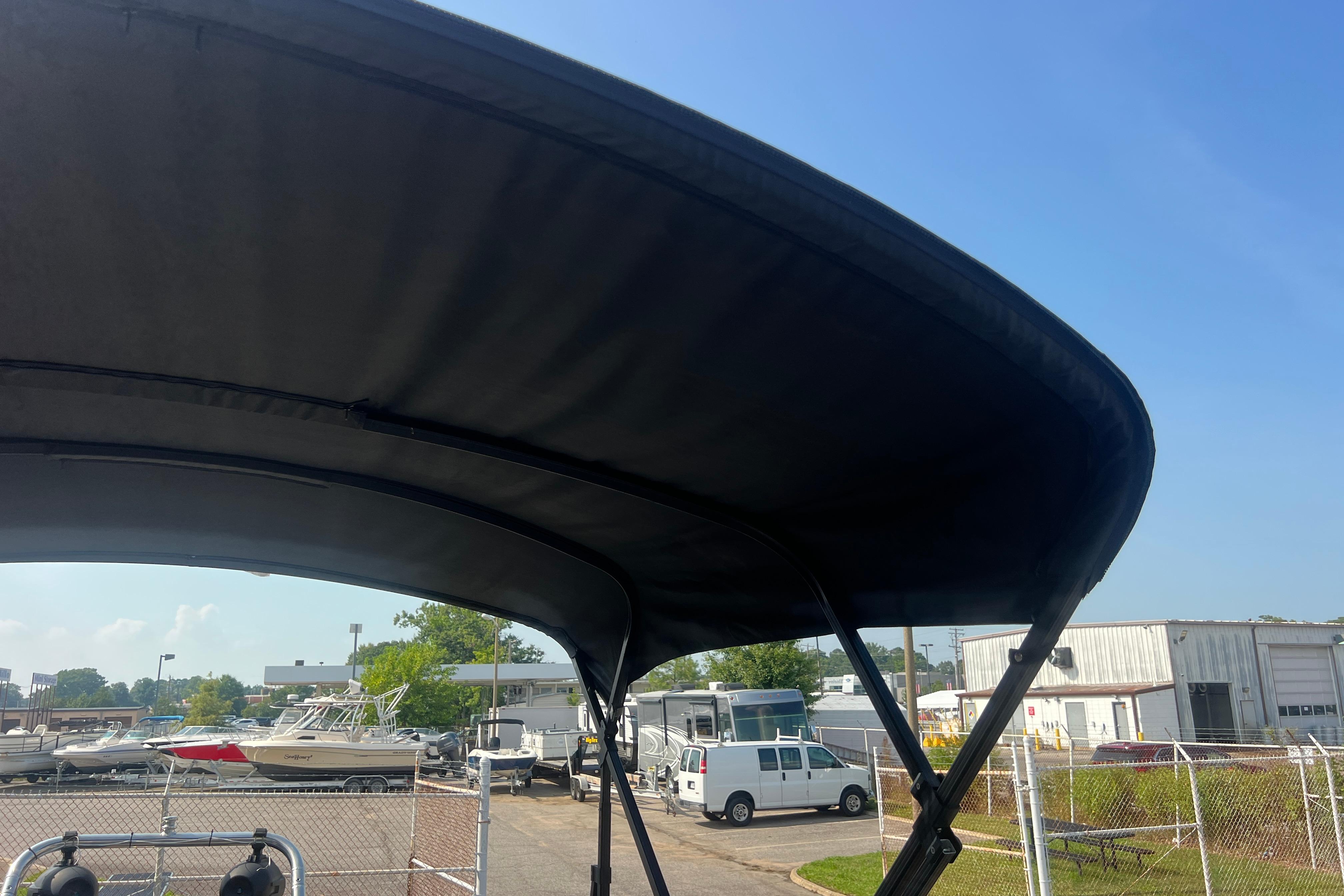 Black canopy of 2022 Viaggio Lago V-U 22 boat in a marina setting.