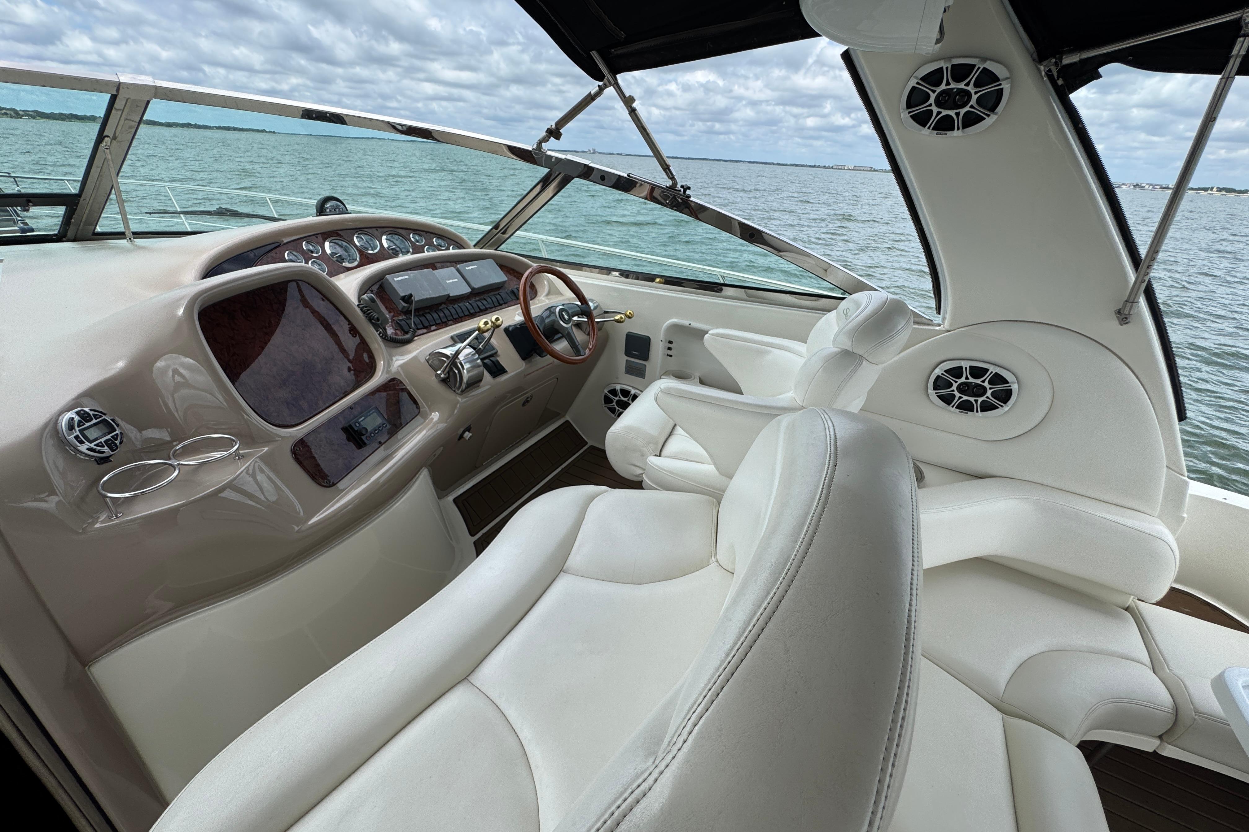 2001 Sea Ray 380 Sundancer helm with luxurious white seating and modern controls.