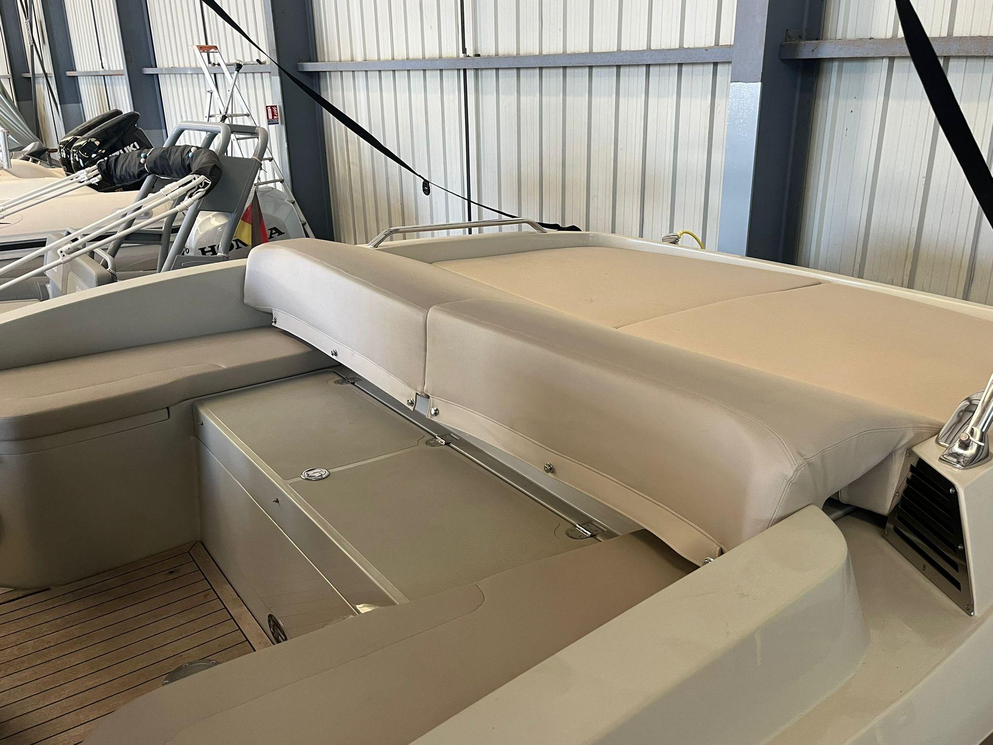 Interior view of a luxury boat with beige seating, stored indoors.