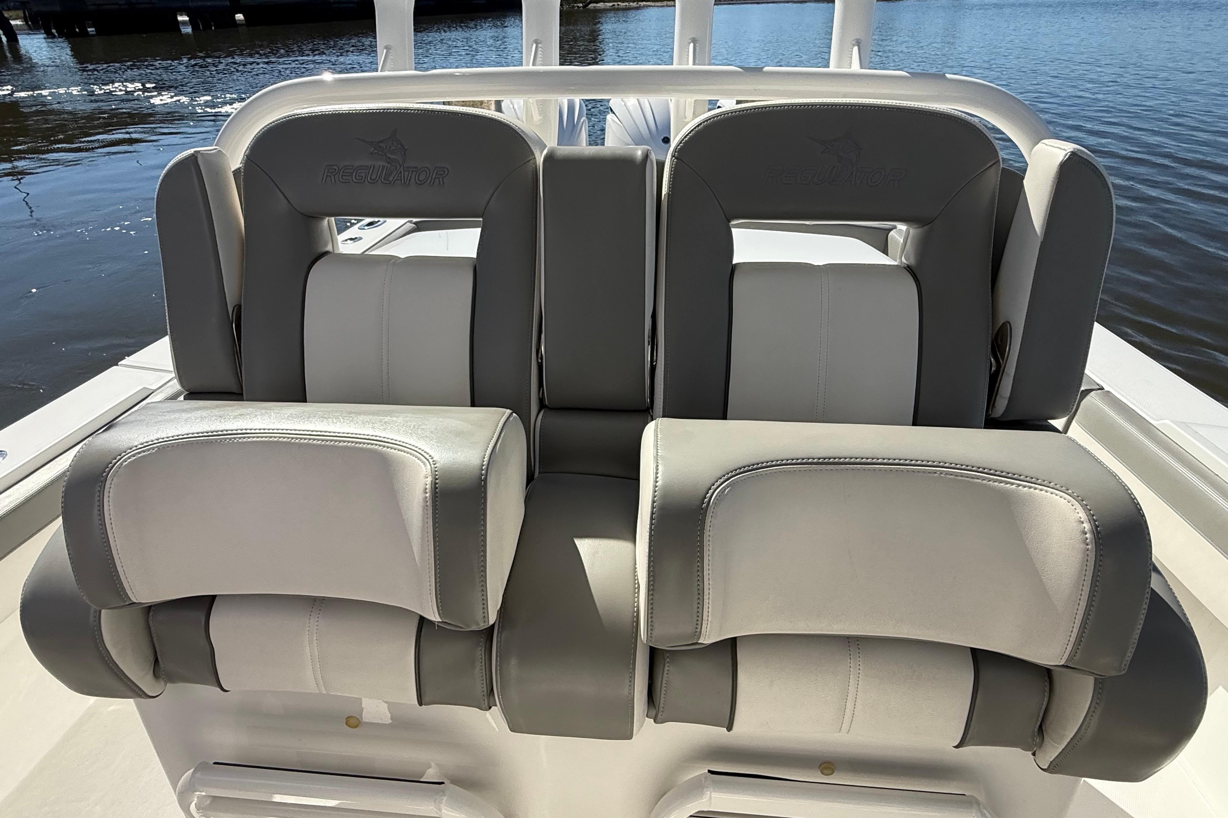 2022 Regulator 34 boat seats with gray and white upholstery, docked by the water.