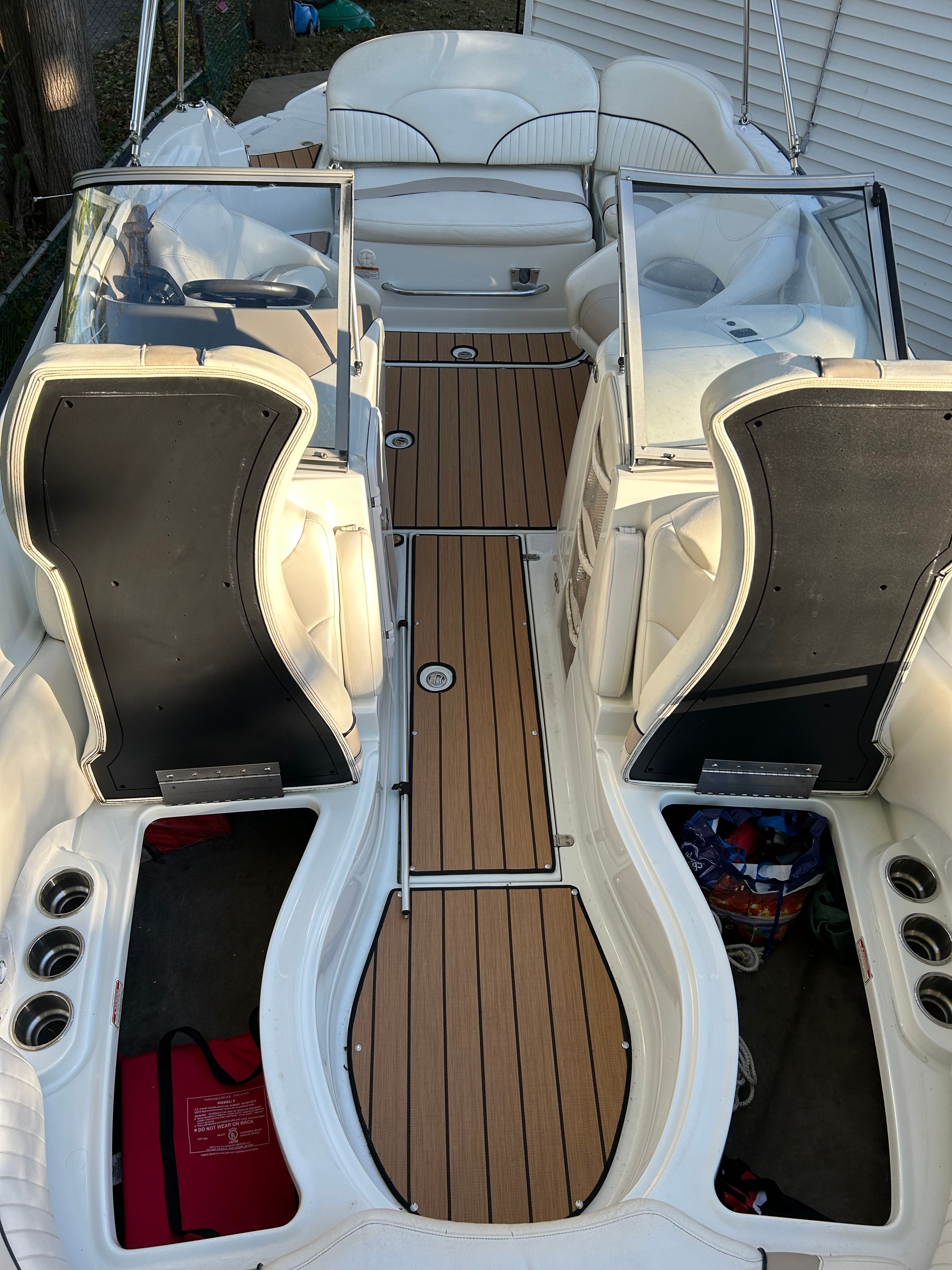 The image shows the cockpit of a 2008 Azure AZ220 boat with wood flooring and white seats.