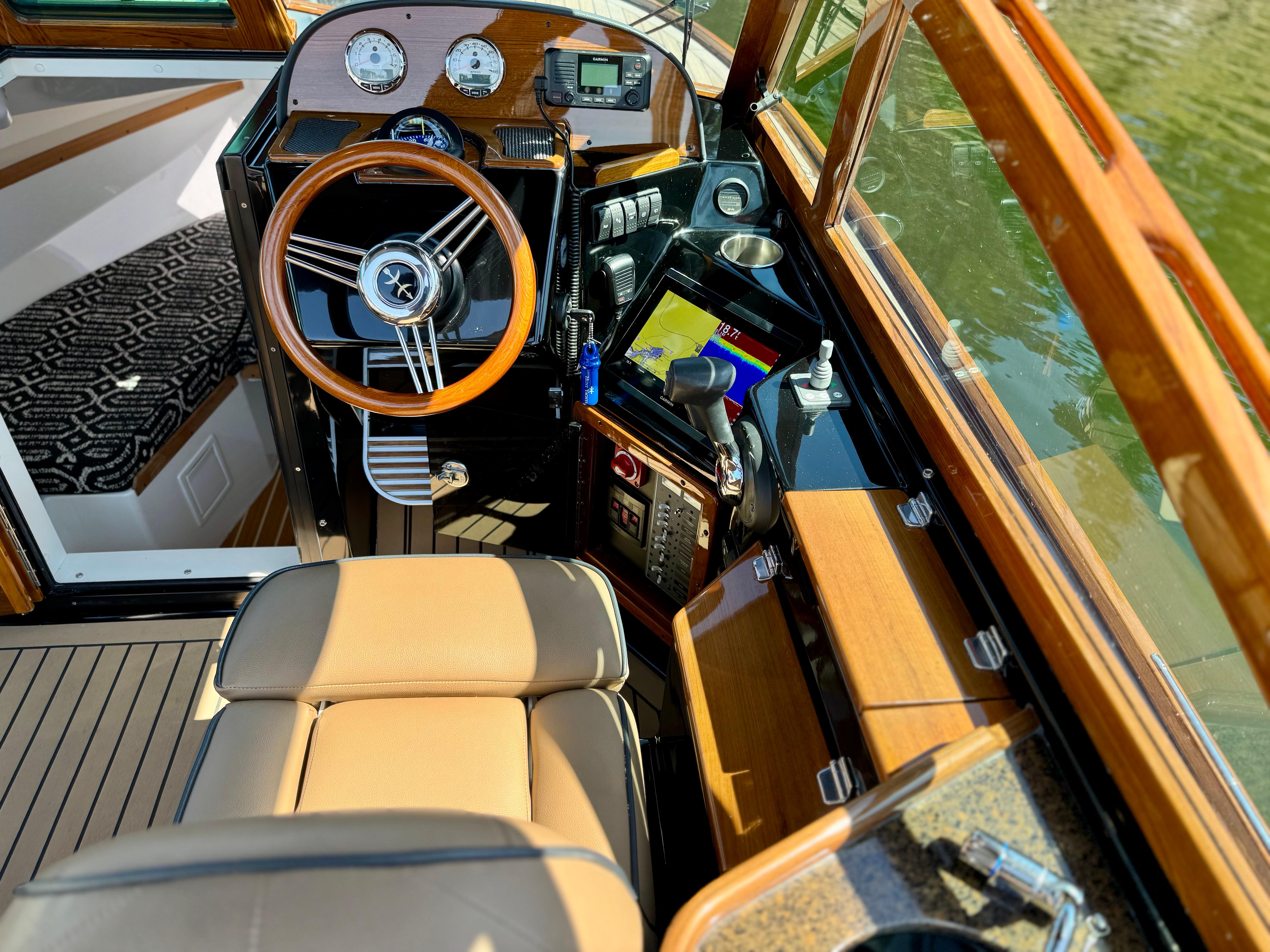 2021 Hunt Yachts Harrier 26 cockpit with wooden steering wheel and modern navigation instruments.