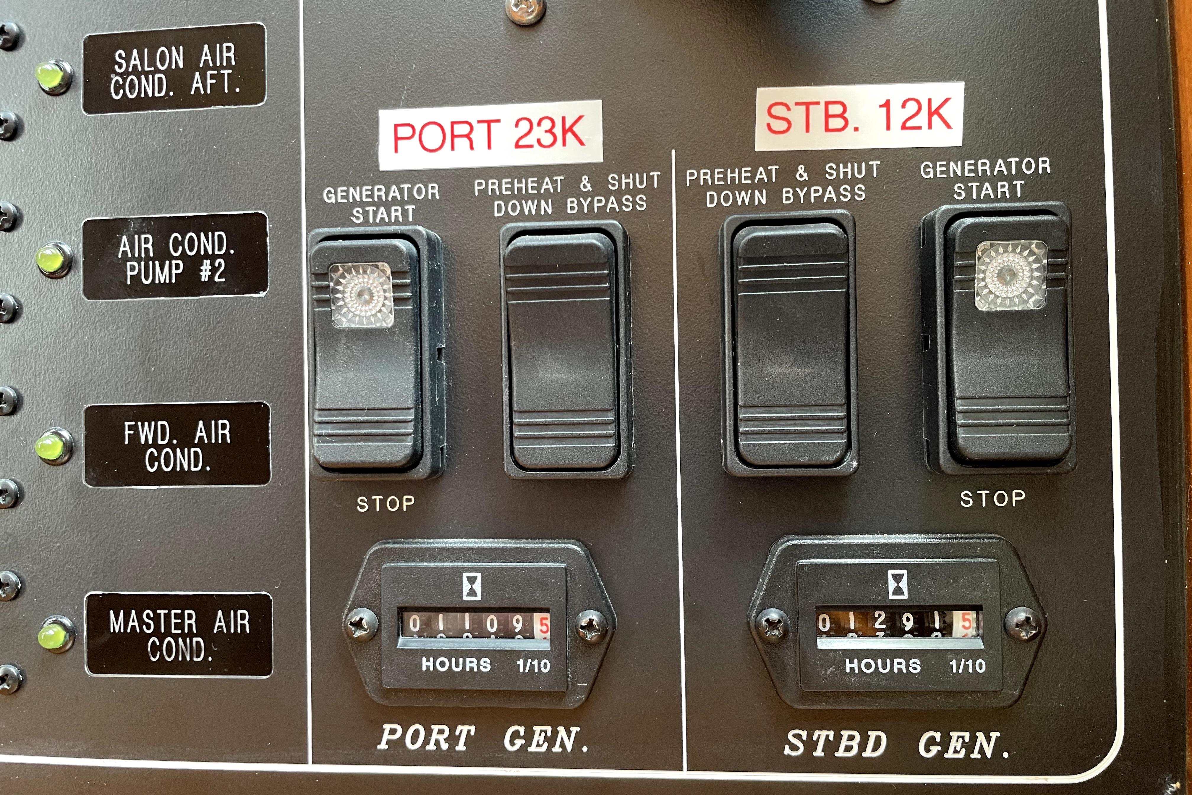 Control panel of a 2005 Ocean Alexander 64 yacht, showing generator switches and hour meters.