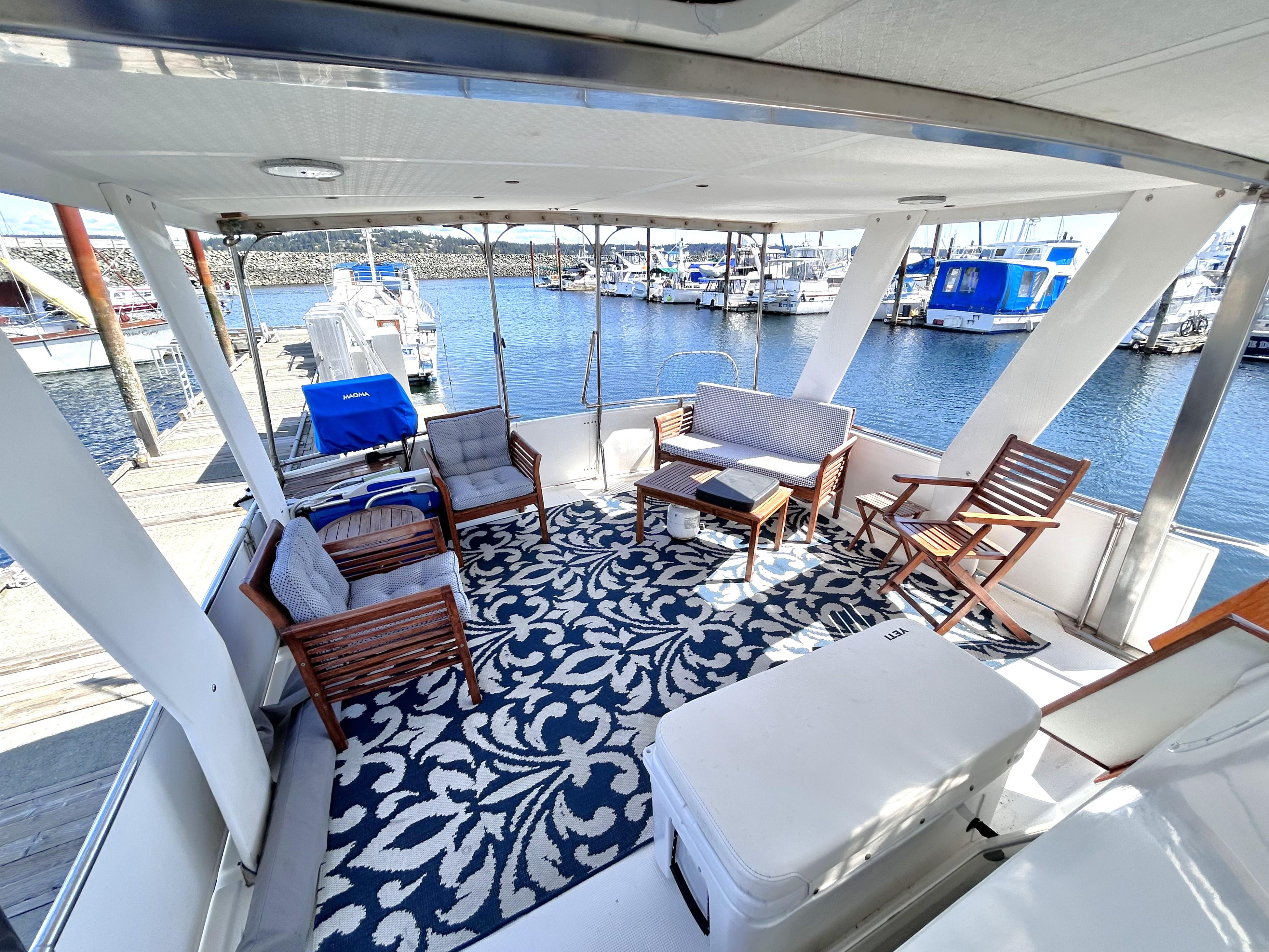 1987 Marine Trader 44 Sunbridge Trawler deck with seating, patterned rug, and marina view.