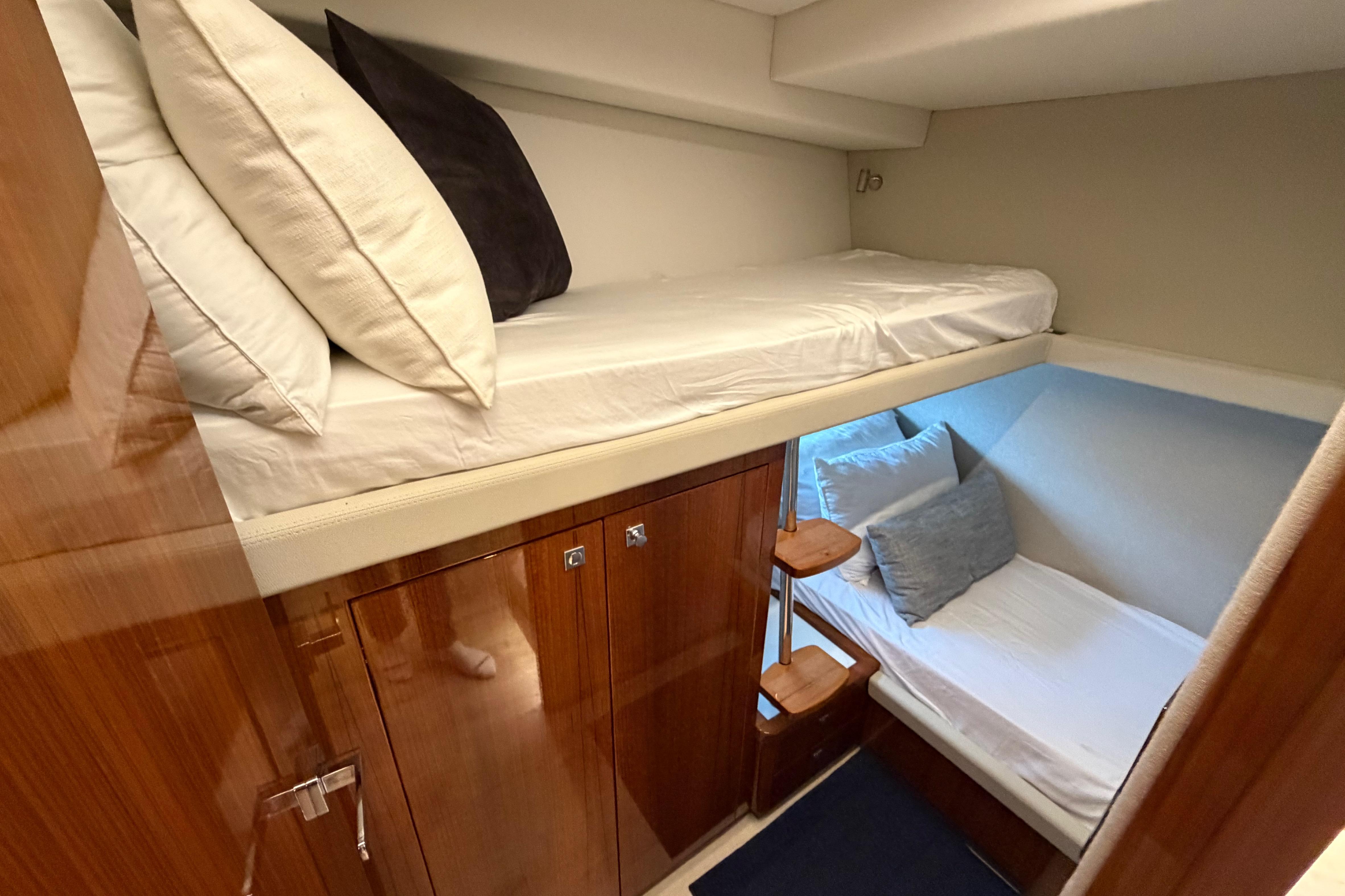 2023 Riviera 645 SUV yacht interior with bunk beds and wooden cabinetry.