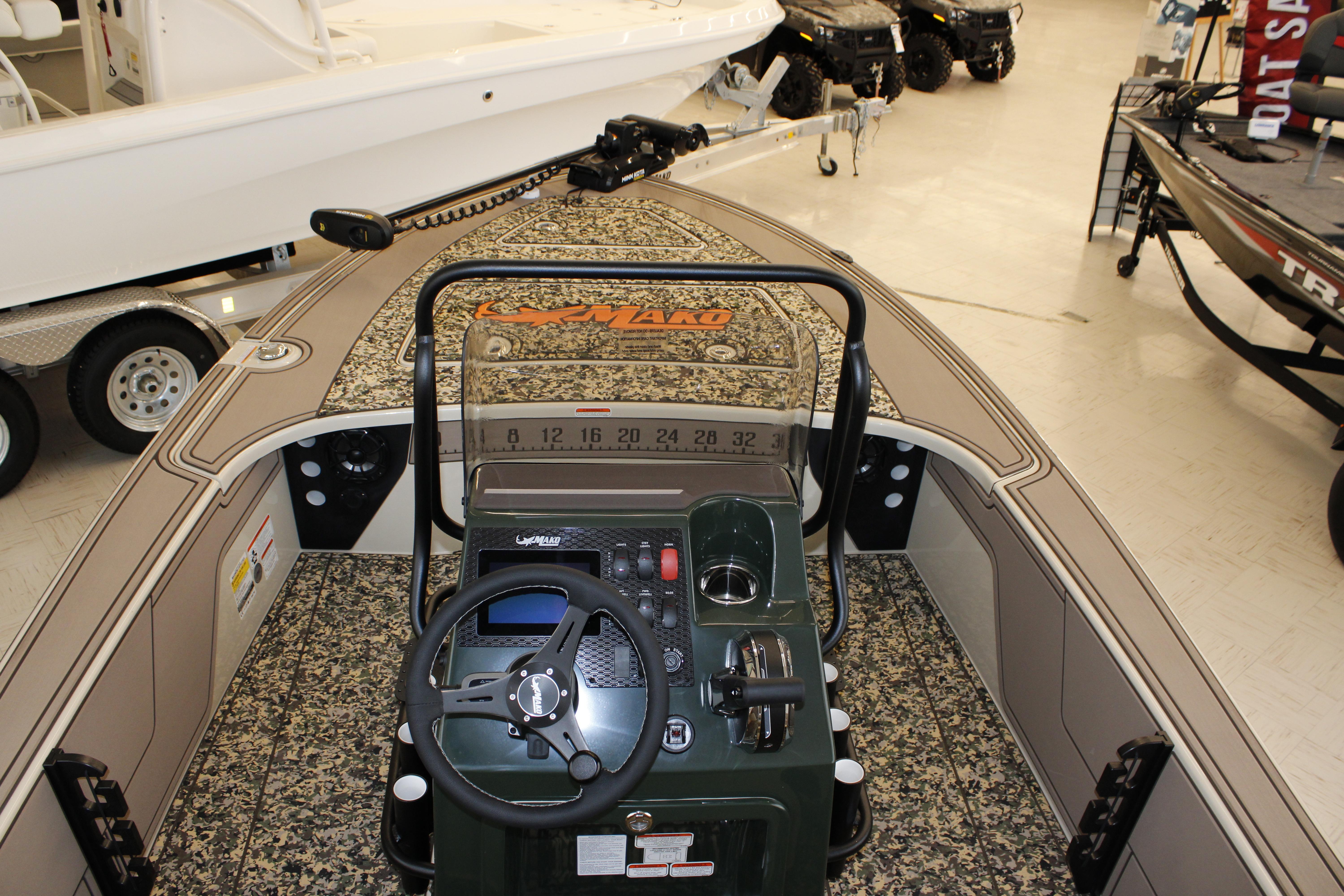 2026 Mako 18 Pro Skiff Backwater Edition boat interior with steering console and camouflage design.