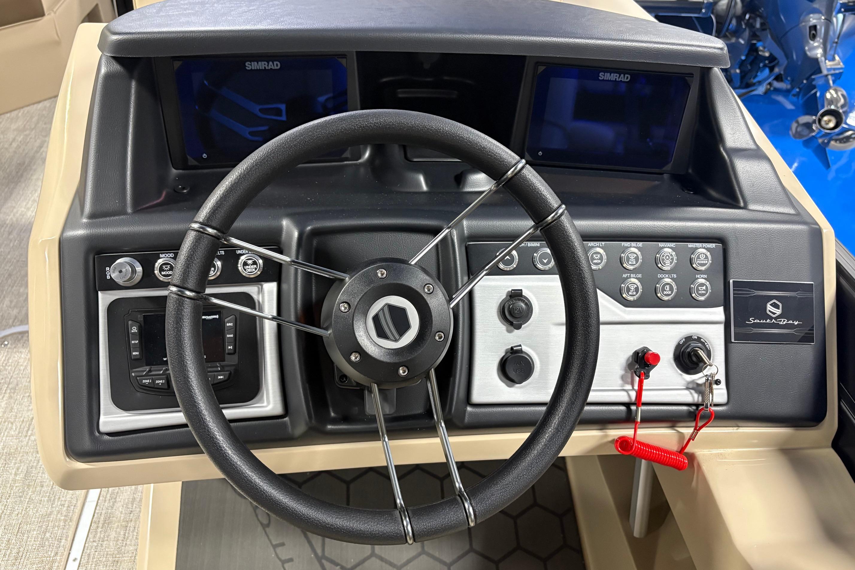 Steering console of 2026 South Bay 523RS boat with control panel and Simrad displays.