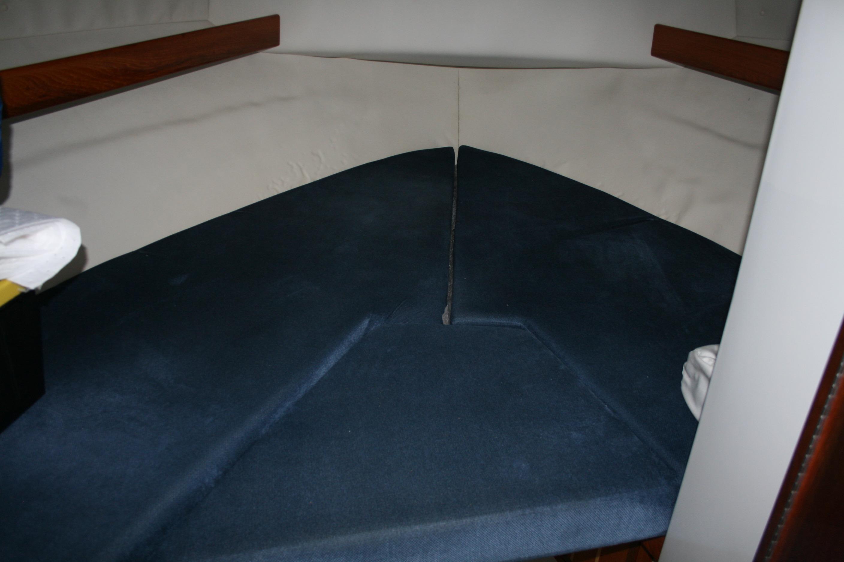 Interior cabin of a 2005 Ocean Sport 30' boat with blue cushions.