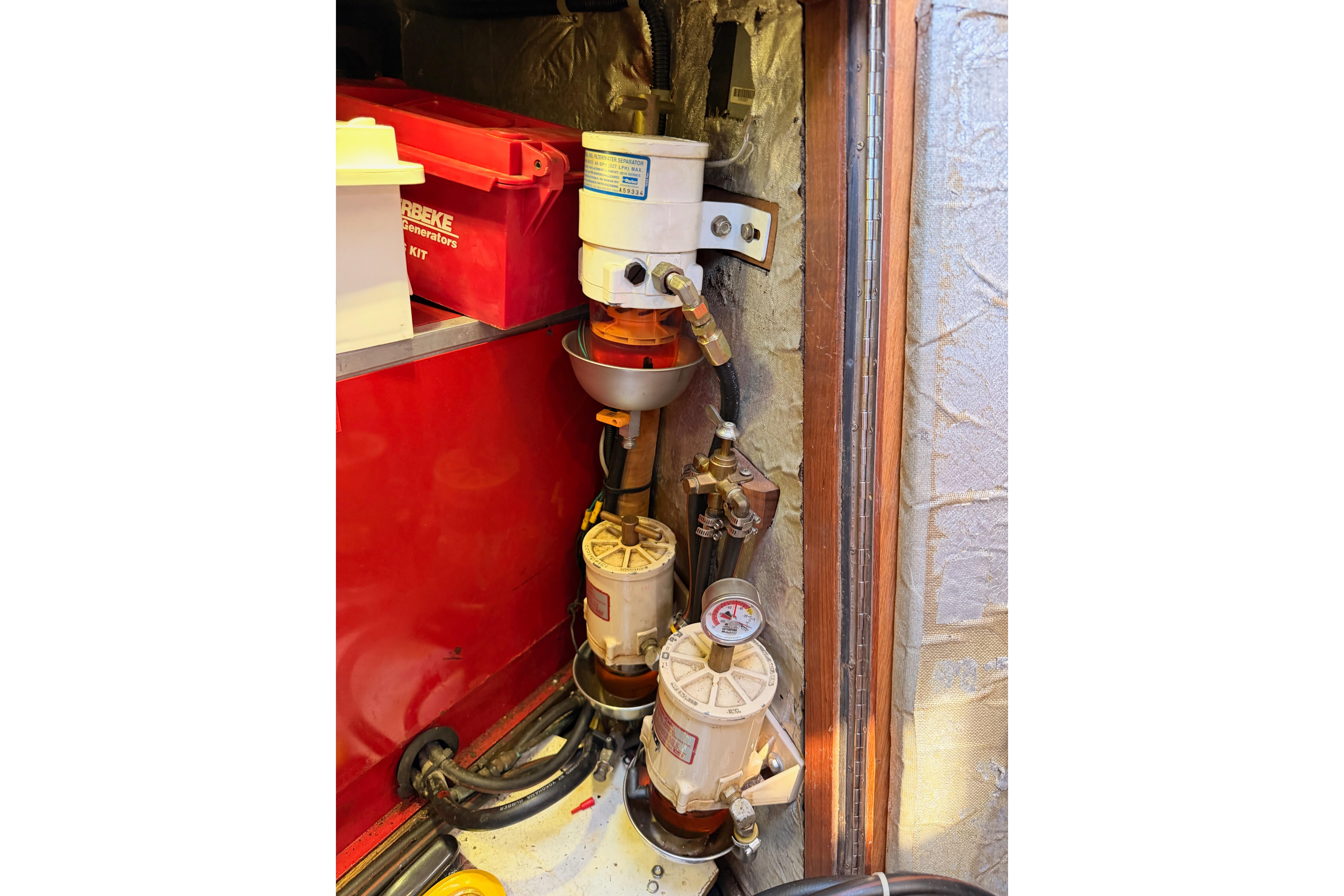 Engine compartment of a 1991 Hylas 51 yacht, featuring fuel filters and generator kit.