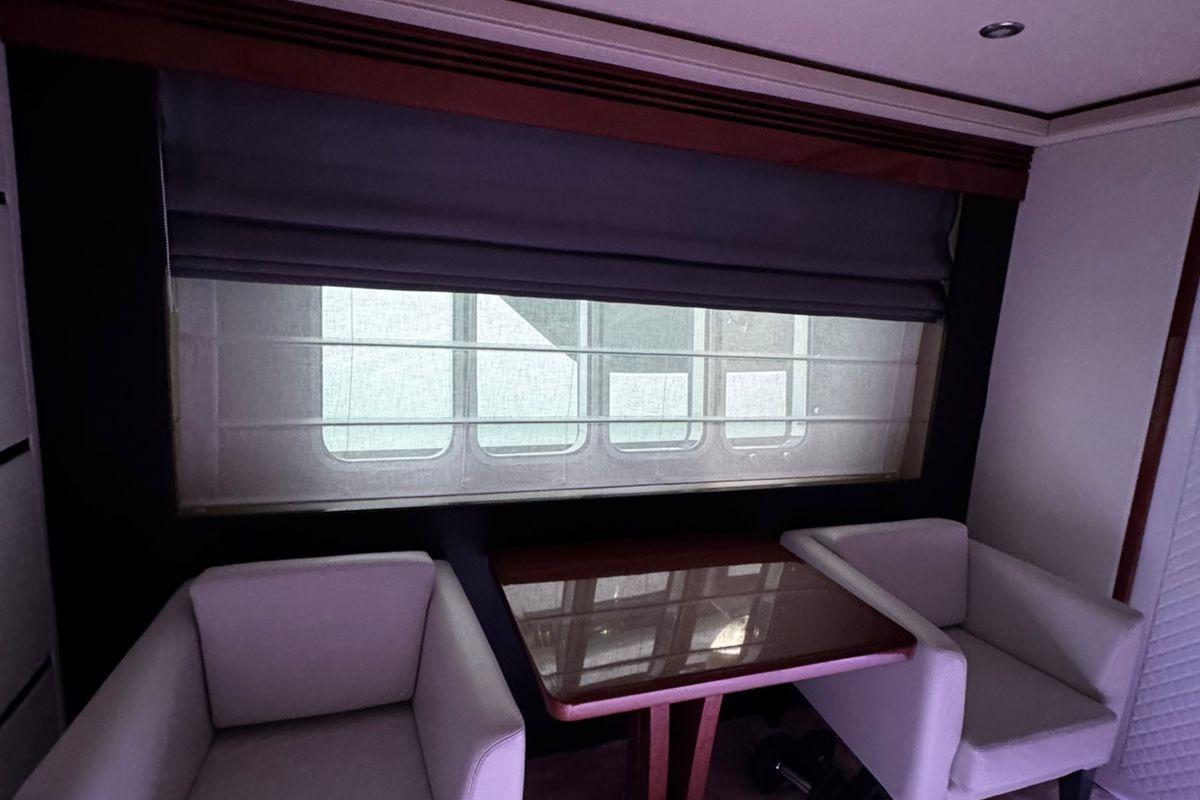 Interior of 2008 Princess V85 yacht with table and chairs by window.