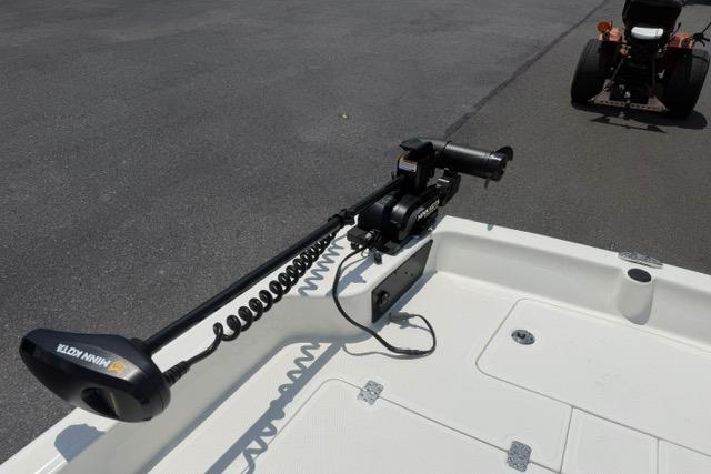 2025 Mako Pro Skiff 17 CC with trolling motor on deck, parked on pavement.