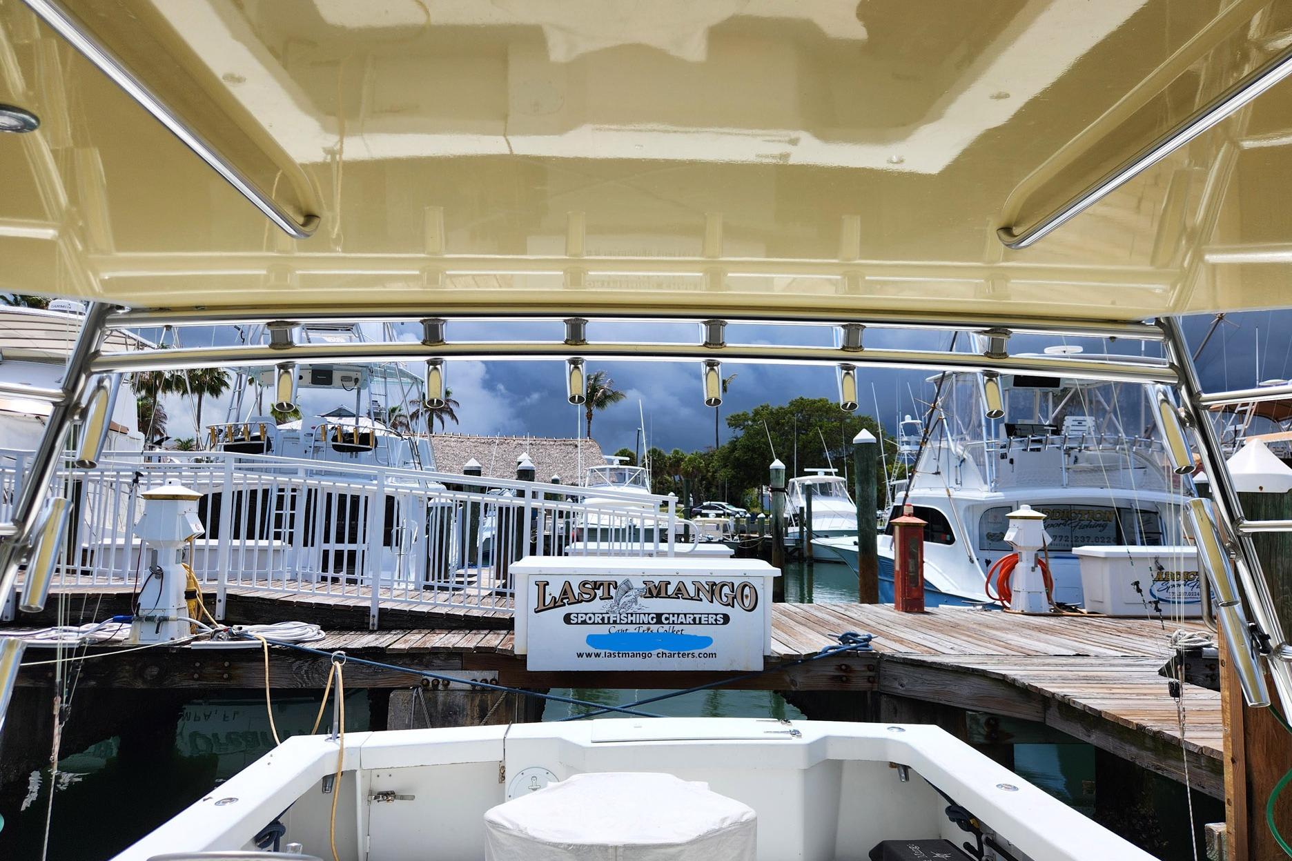 1987 Young Brothers Custom Sport Fish boat docked at marina with stormy sky.
