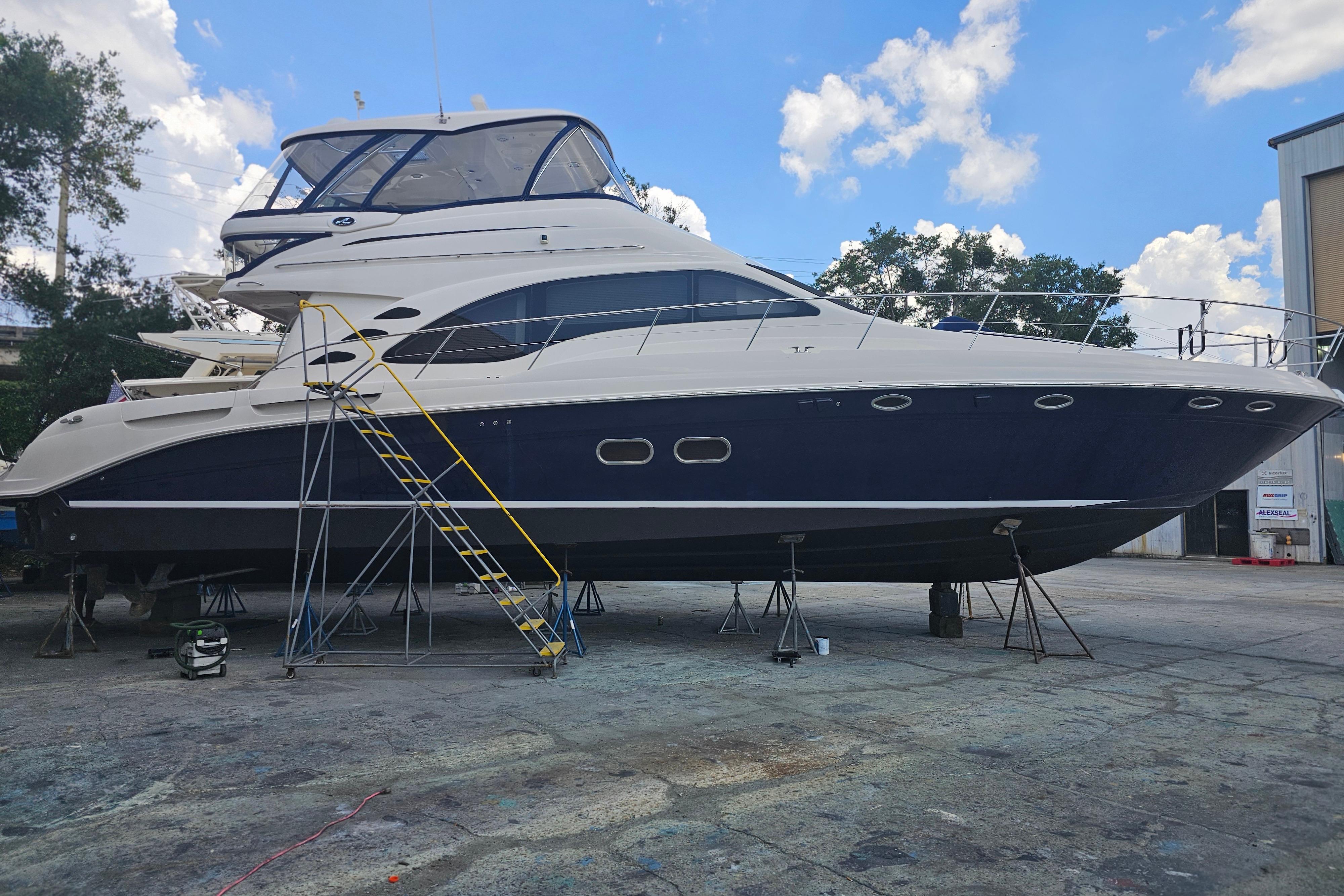 2006 Sea Ray 580 Sedan Bridge yacht on dry dock under a clear blue sky.
