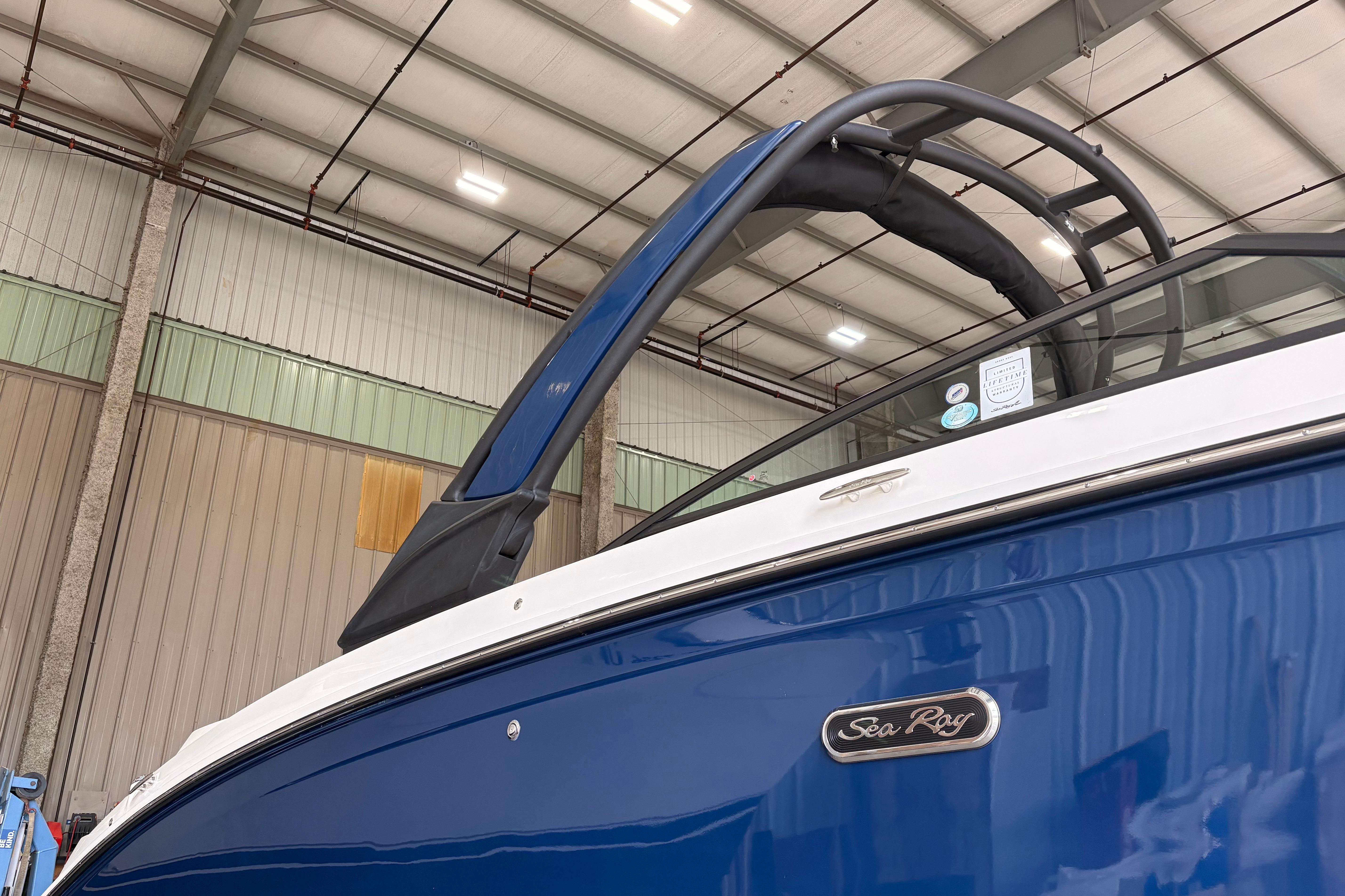 2026 Searay 290 SDX boat in a warehouse, showcasing sleek blue and white design.
