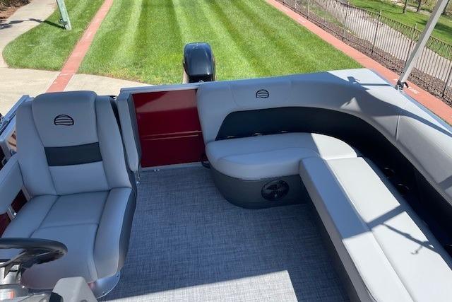 2026 Sun Tracker Party Barge 16 DLX interior with gray seating and outdoor view.