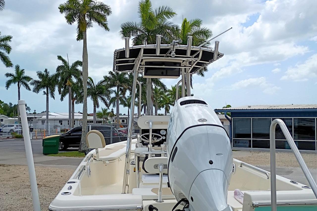 2023 Bulls Bay 2200 boat with outboard motor, parked near palm trees and buildings.