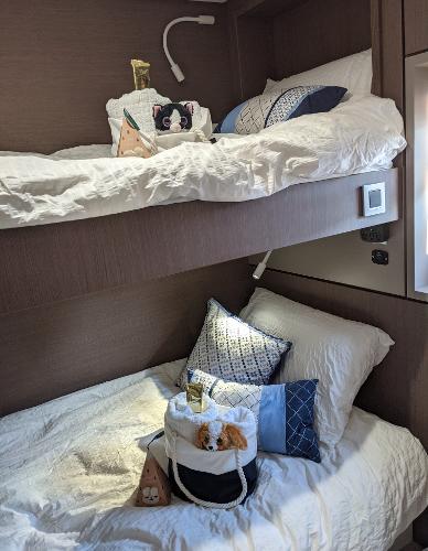 Cozy bunk beds in a 2021 Bali 4.8 yacht cabin with plush pillows and decor.