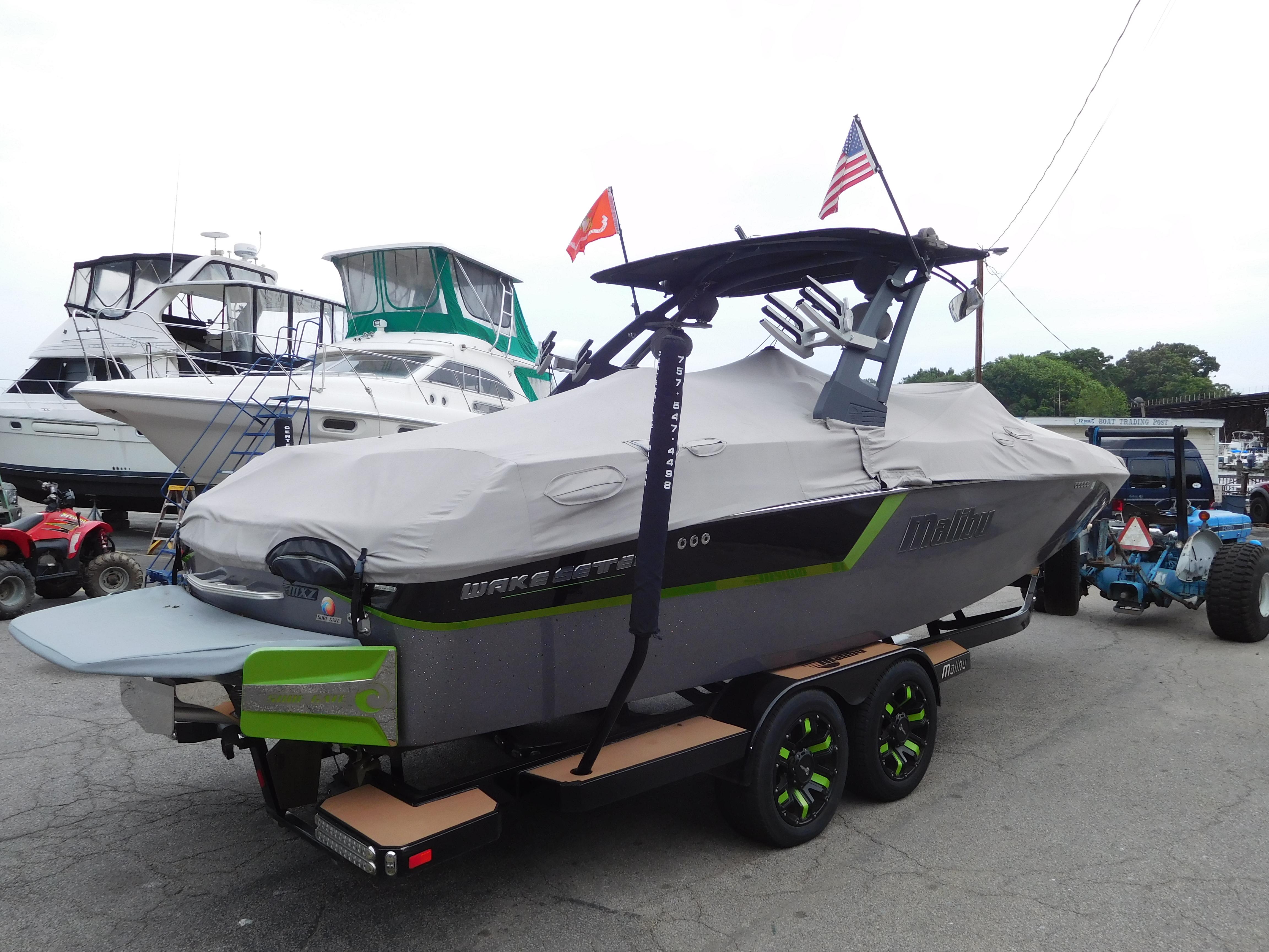 2017 Malibu Wakesetter 24 MXZ boat covered and on a trailer at a marina.