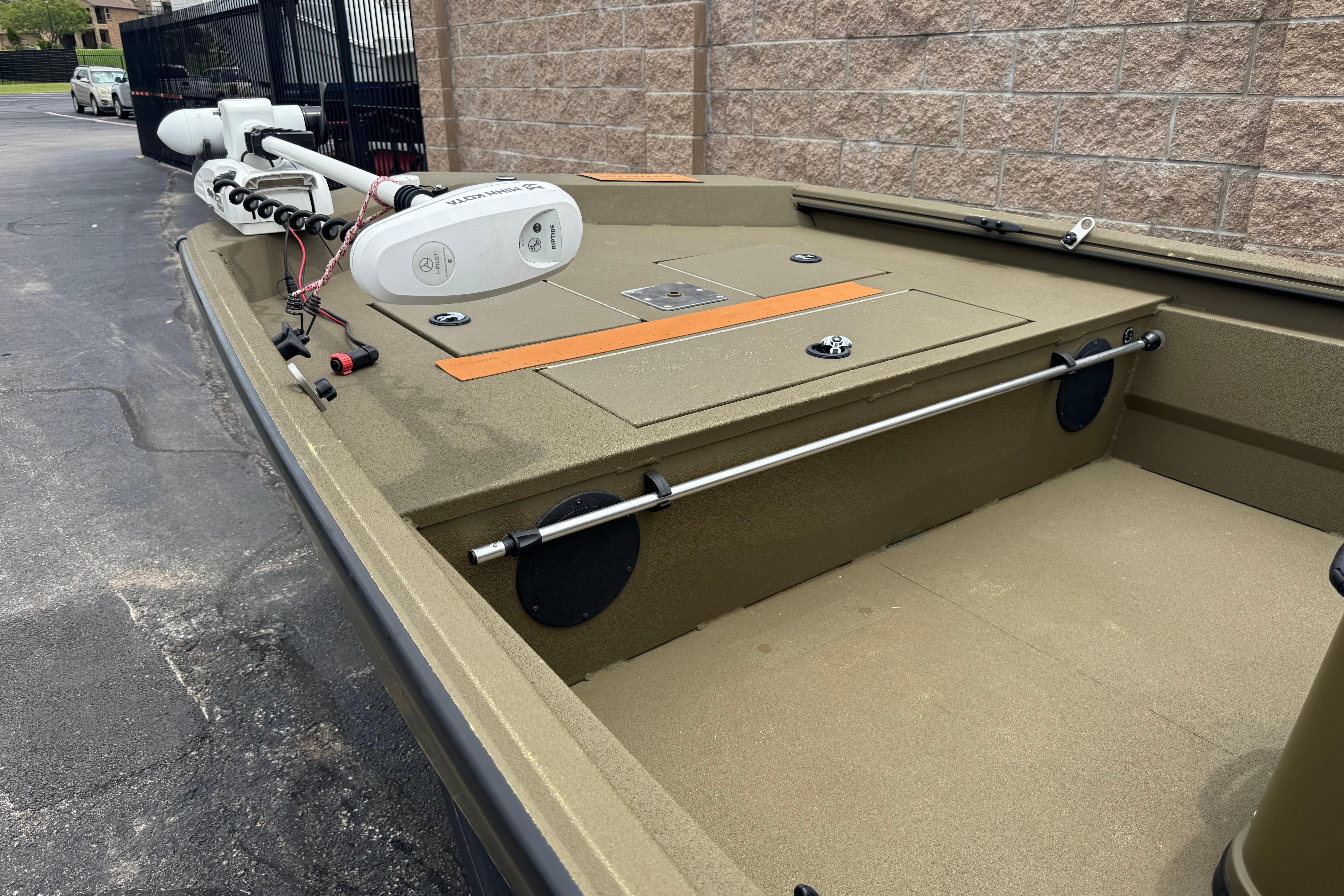 2023 Avid 18 Rogue CC boat with trolling motor, parked on pavement.