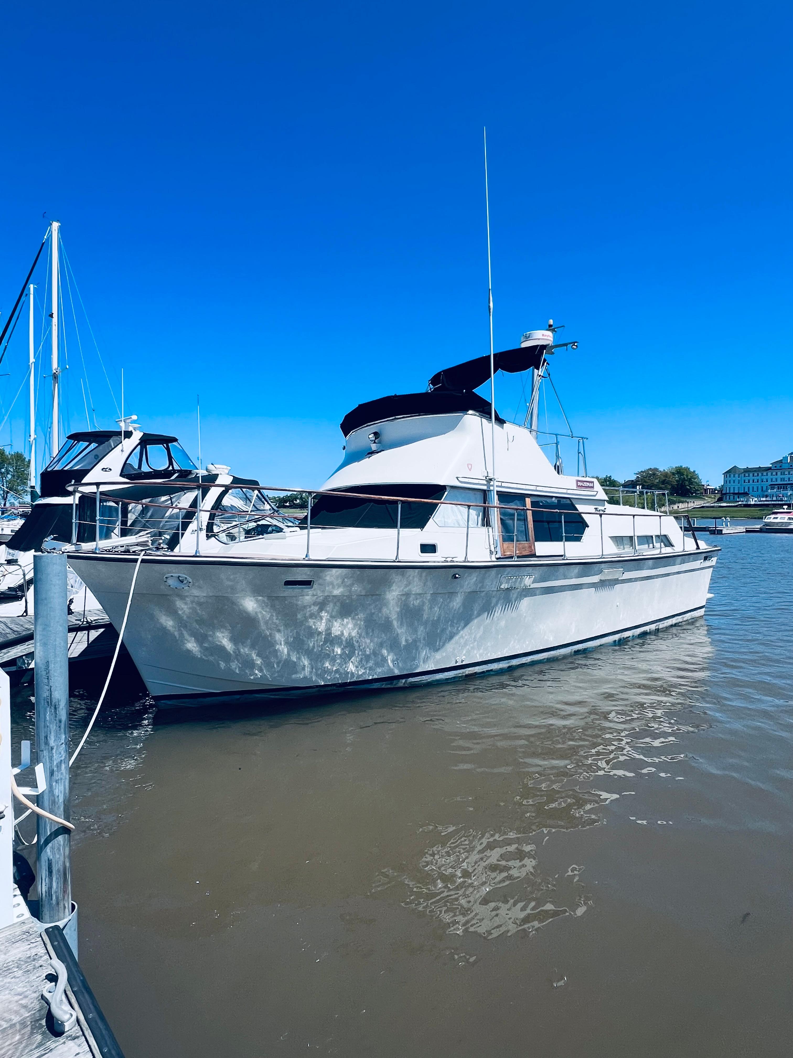 1974 Tollycraft 40 Tri-Cabin Motoryacht docked in a marina under clear blue sky.