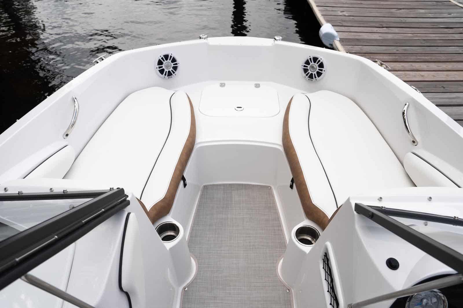 Manufacturer Provided Image: 2026 Stingray 191 DC boat interior with white seating and cup holders at a dock.