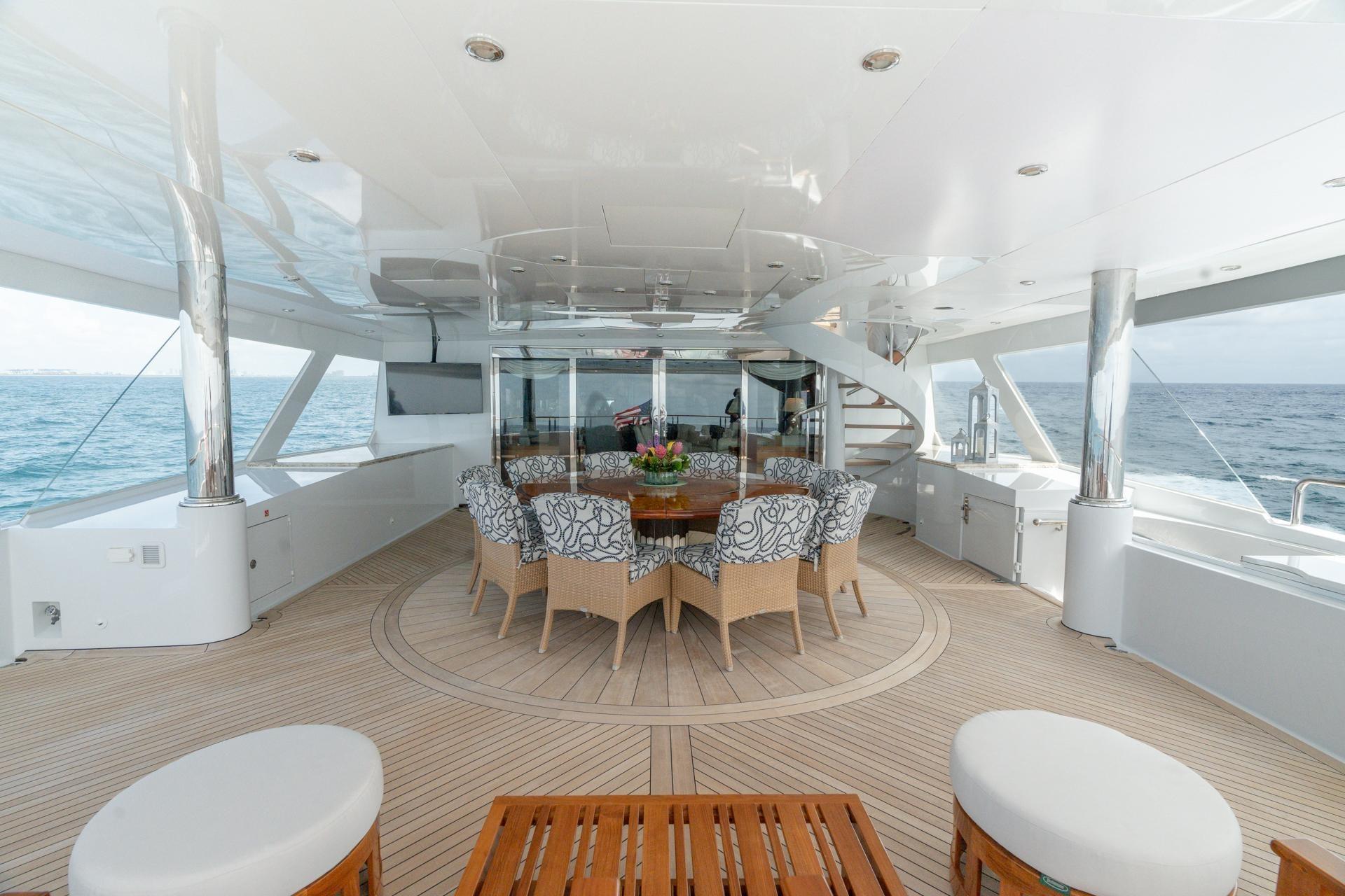 Luxurious 2006 Trinity Tri-Deck Motor Yacht with elegant outdoor seating and ocean view.