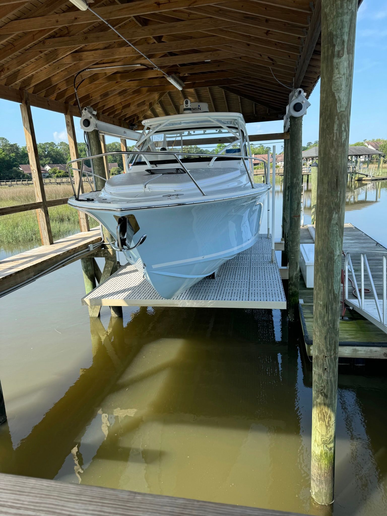A 2024 Albemarle 30 Express boat is lifted in a covered dock.