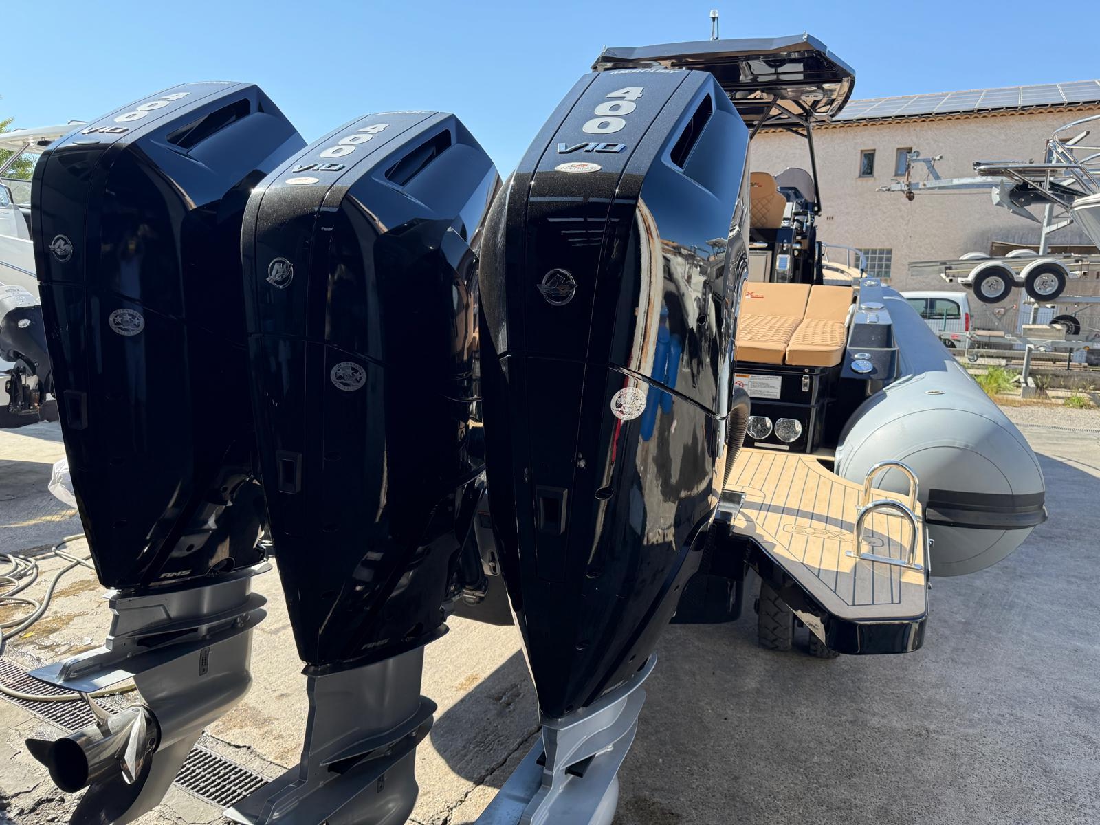 2024 SPX RIB 38 boat with triple outboard engines, docked outdoors.