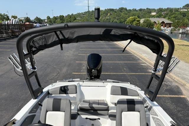 2024 Tahoe T21 boat with seating and canopy, parked in a lot near a scenic area.