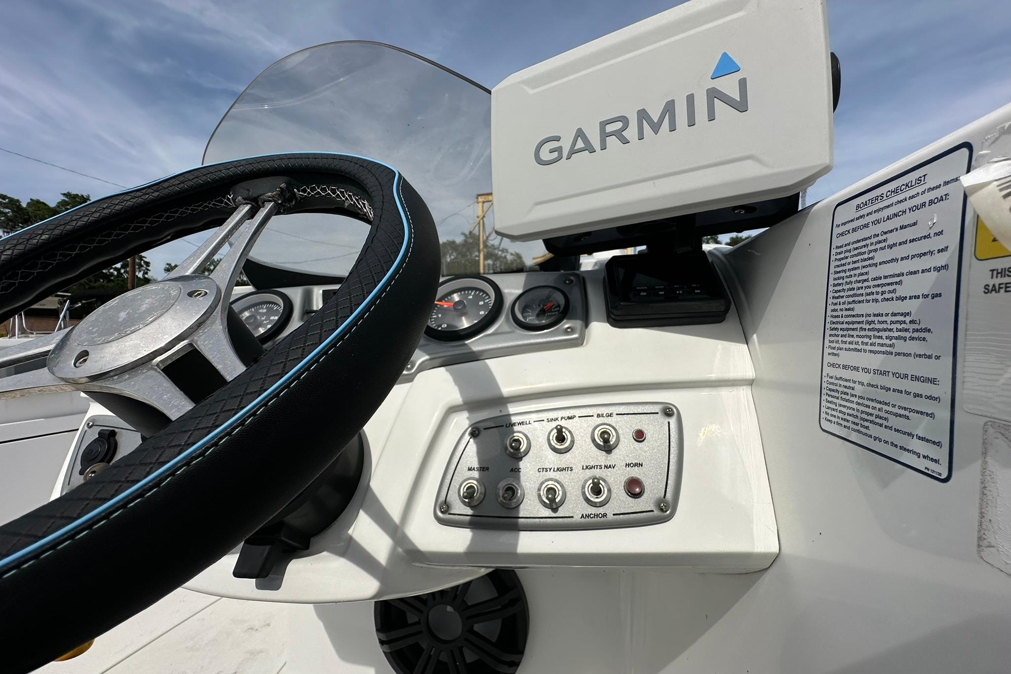 Steering wheel and dashboard of 2021 Tahoe 2150 boat with Garmin navigation system.
