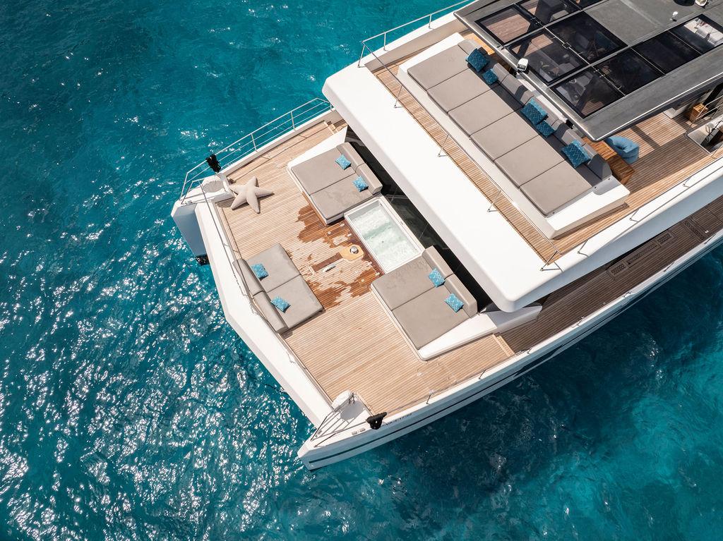 Luxurious Sunreef Supreme 68 yacht, 2017 model, with spacious deck on clear blue water.