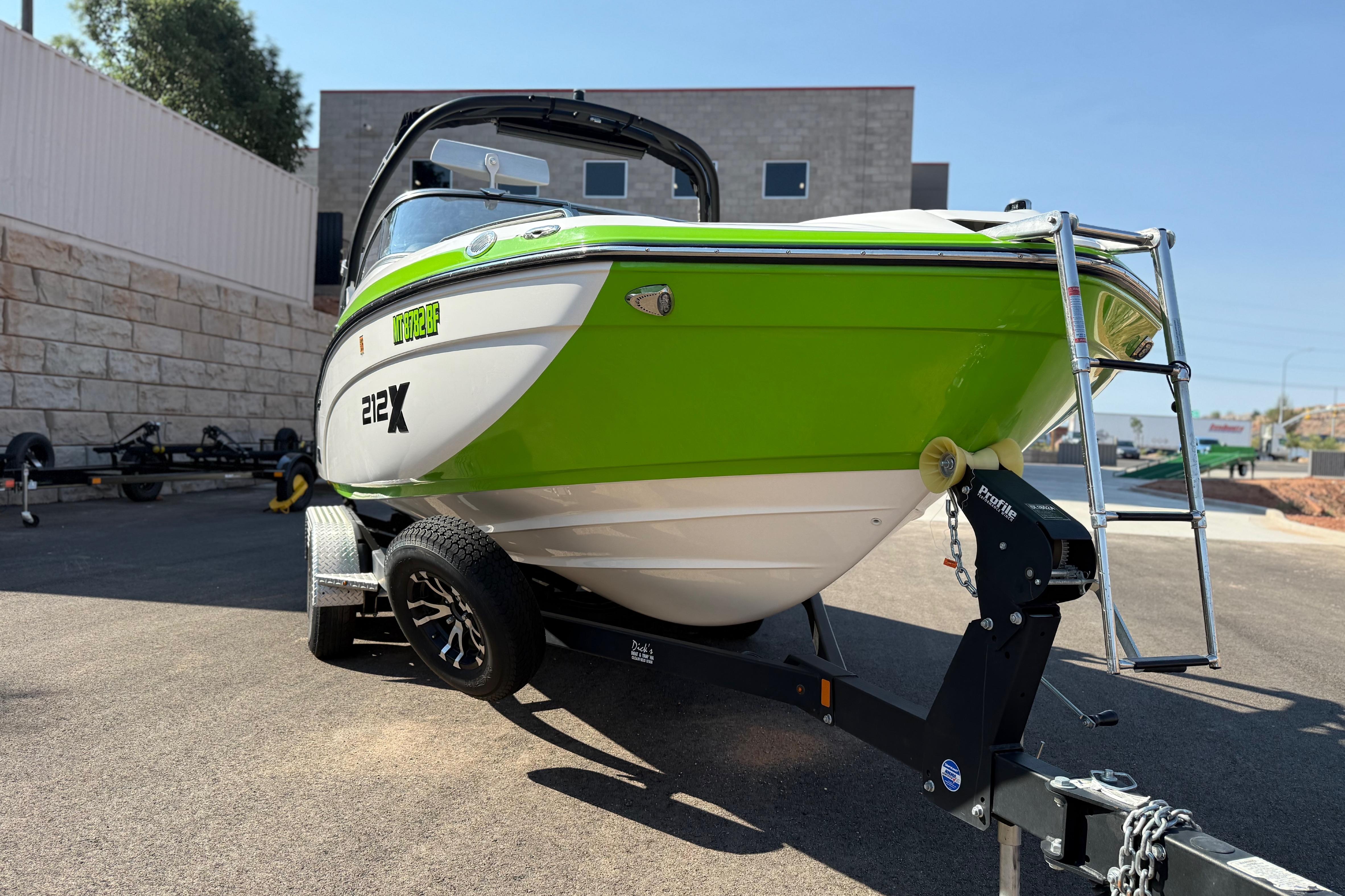 2022 Yamaha Boats 212XE in vibrant green on trailer, parked outdoors.