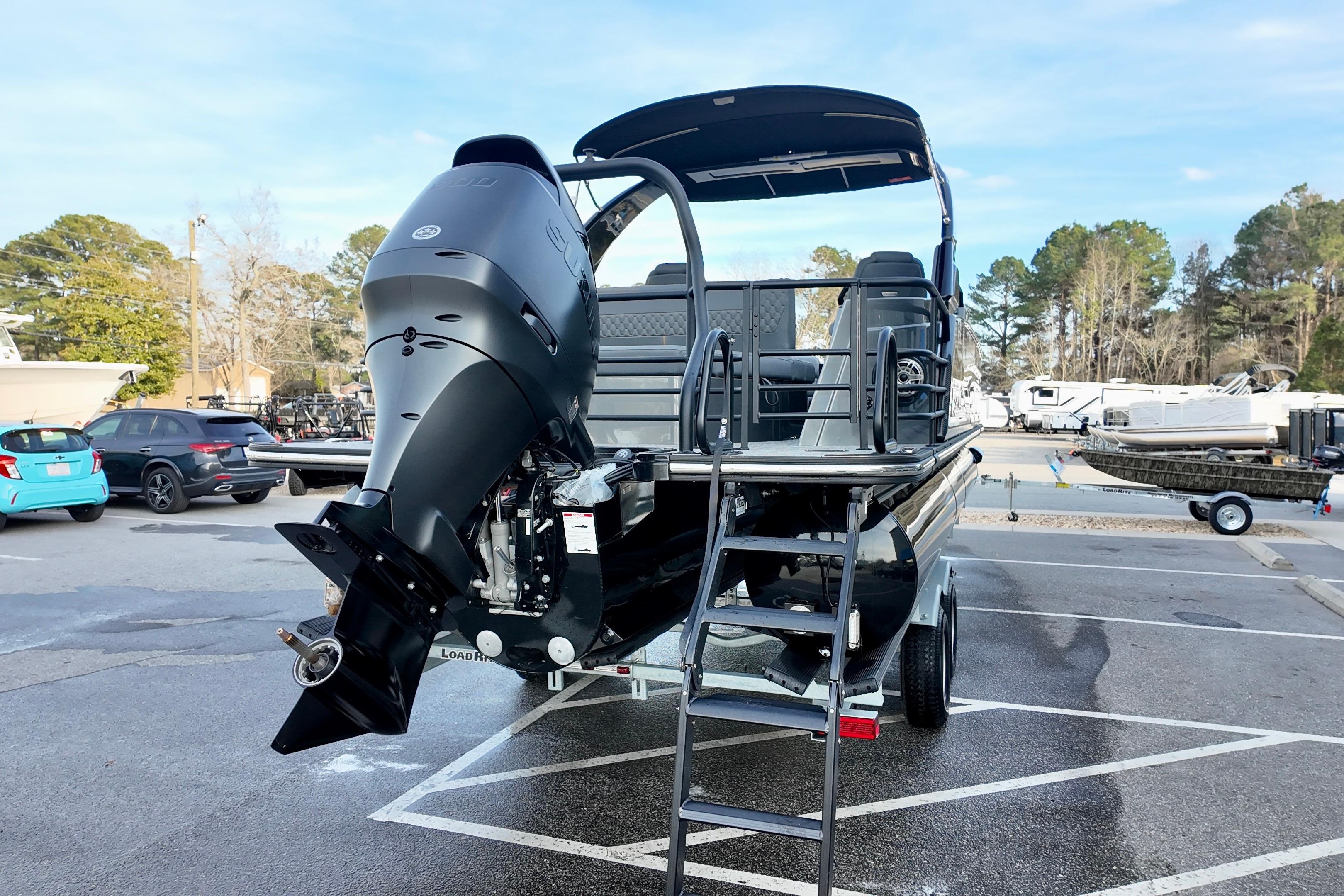 2026 Sylvan M-5 CLZ DC boat with outboard motor in a parking lot.