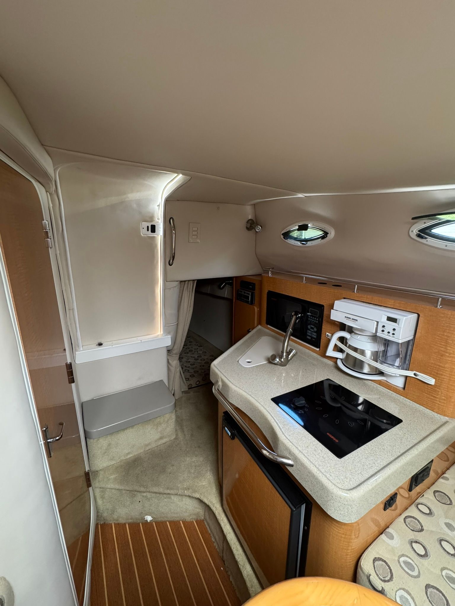 Interior of a boat cabin with a kitchenette and sink.