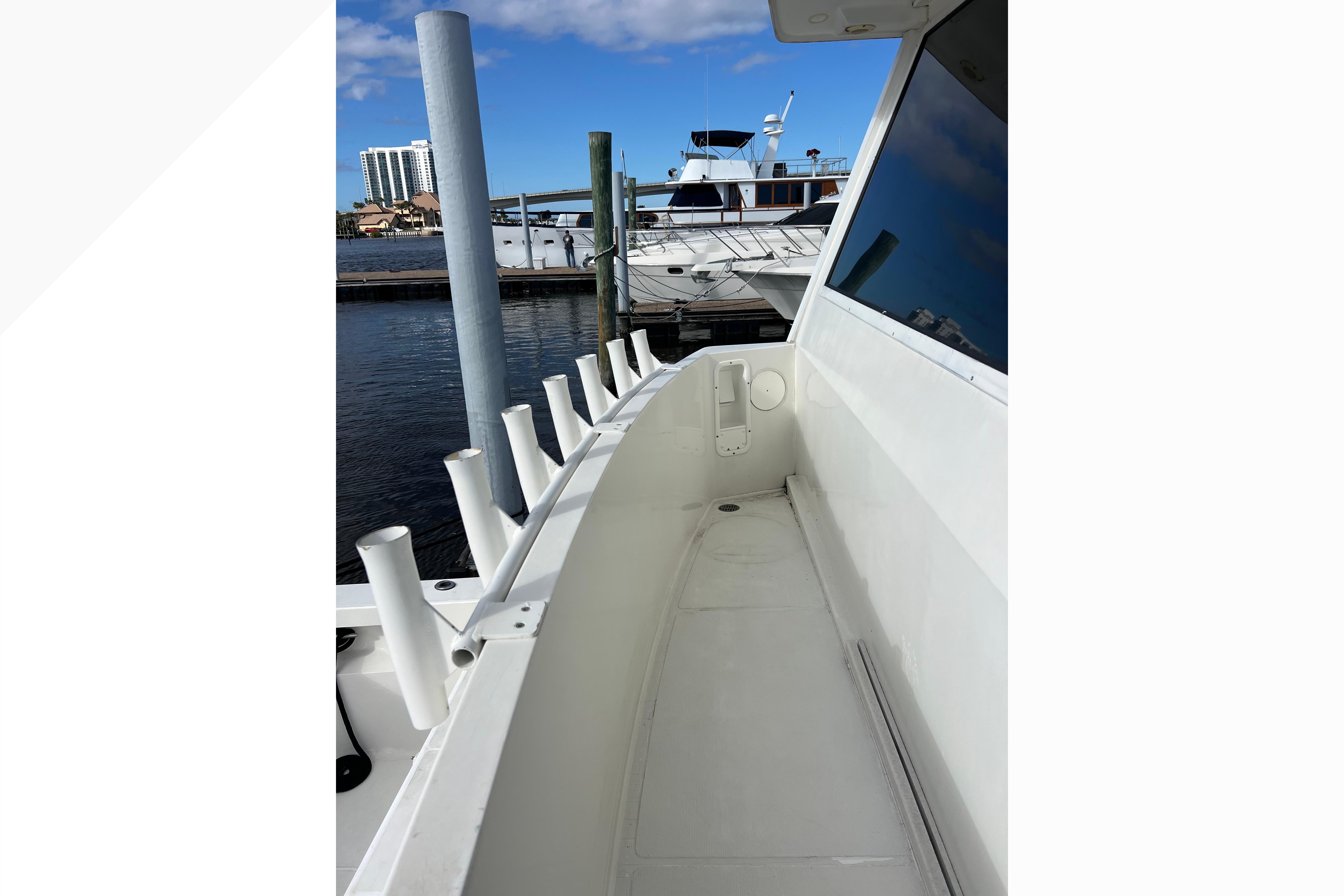 1999 Viking 60 CPMY yacht deck with rod holders, docked at marina.