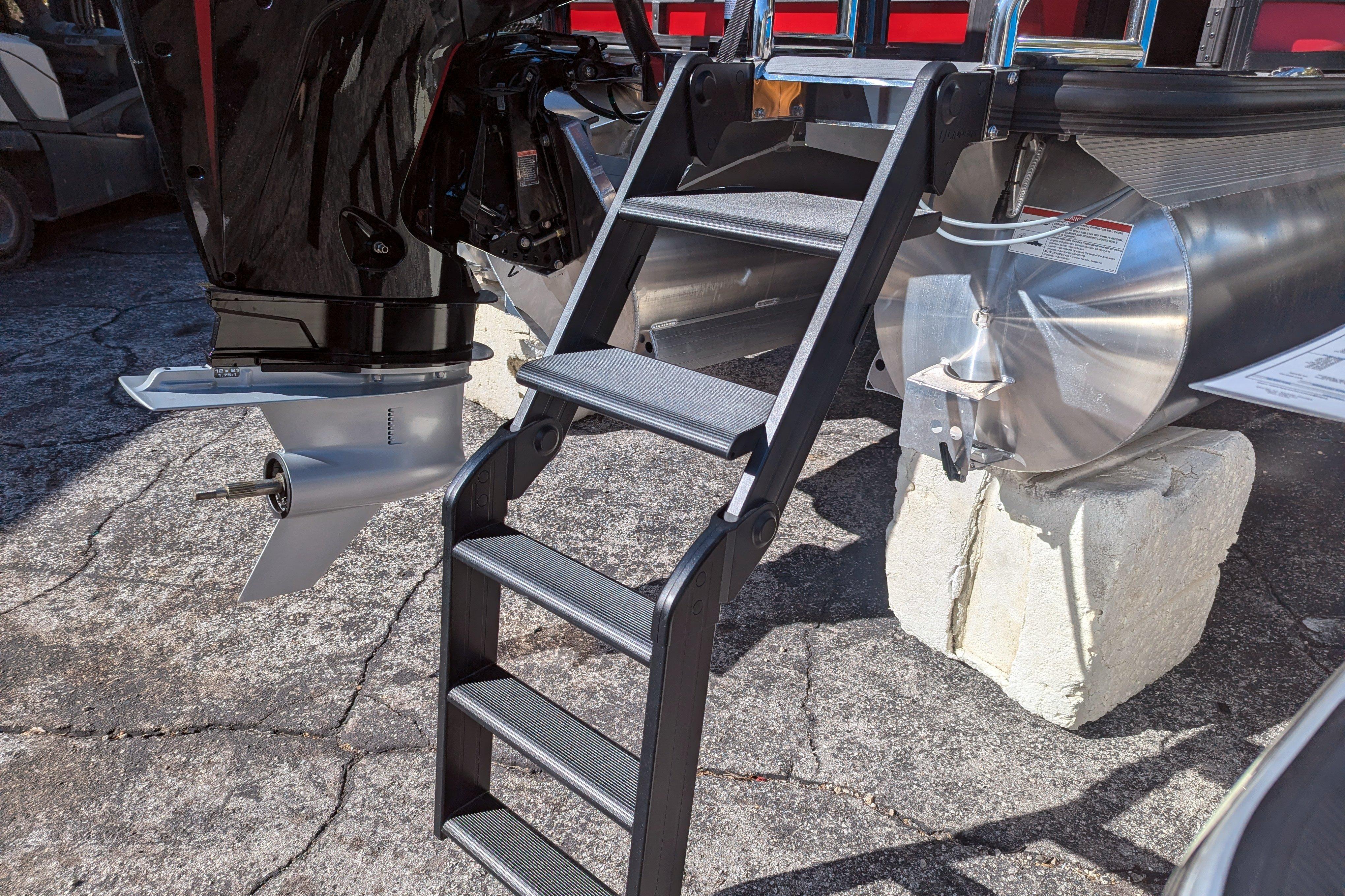 Ladder and motor of 2026 Trifecta 21C SS pontoon boat on display.