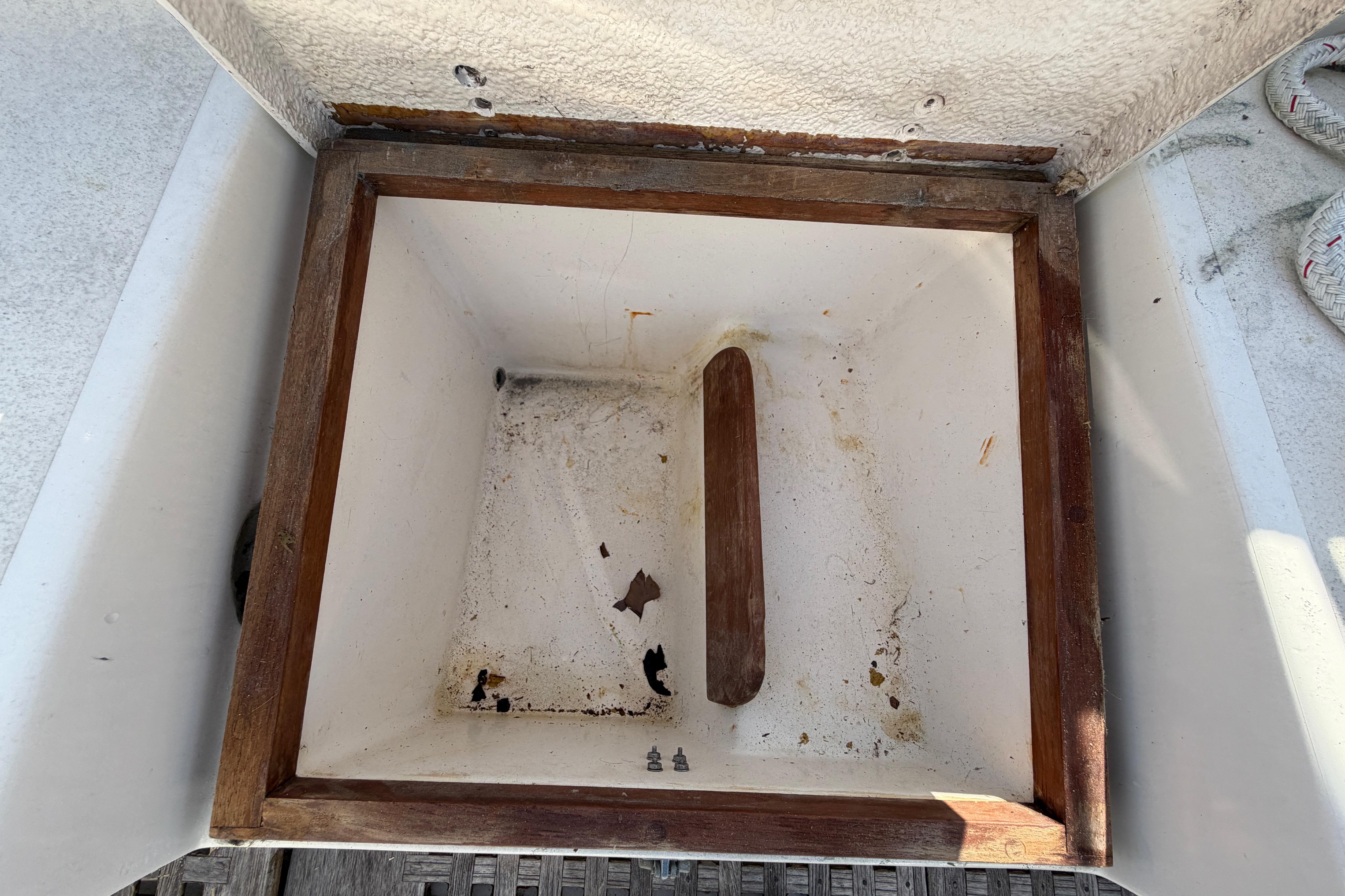 Open storage compartment on 1983 Morgan Catilina boat, featuring wooden frame and white interior.