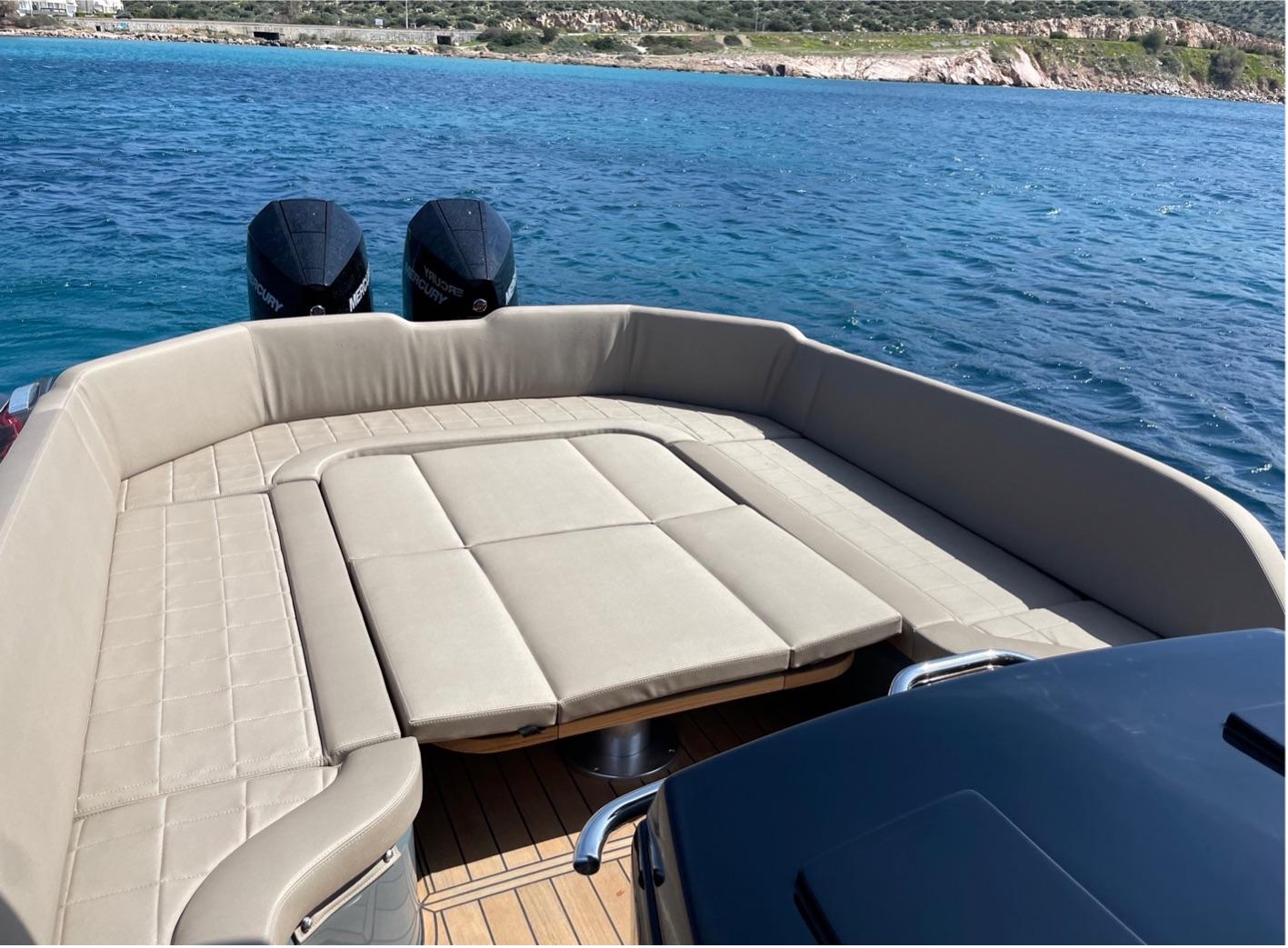 2023 SACS Strider 11 boat with beige seating, dual engines, and scenic ocean view.