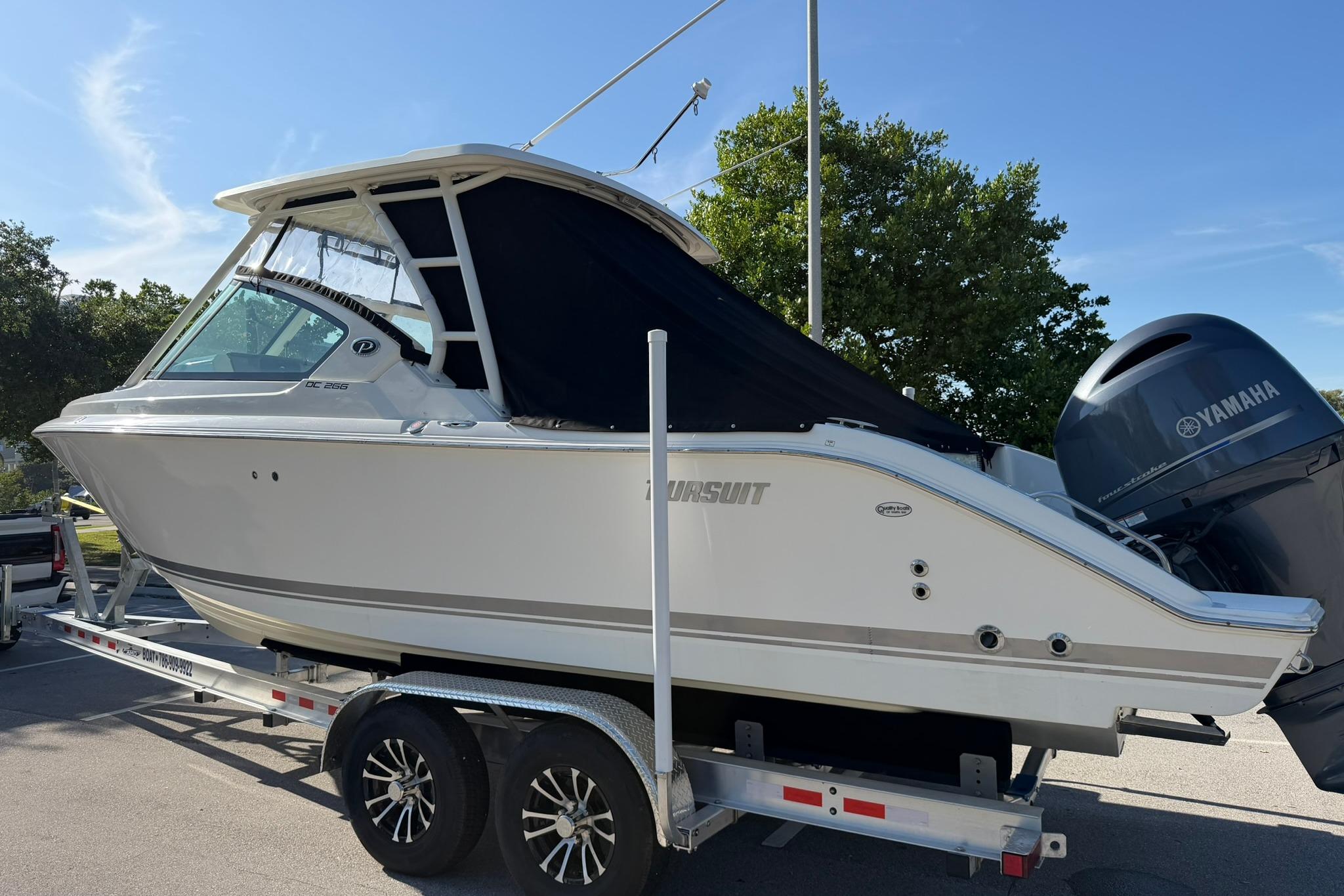 2021 Pursuit DC 266 Dual Console boat on trailer, featuring Yamaha outboard motor.