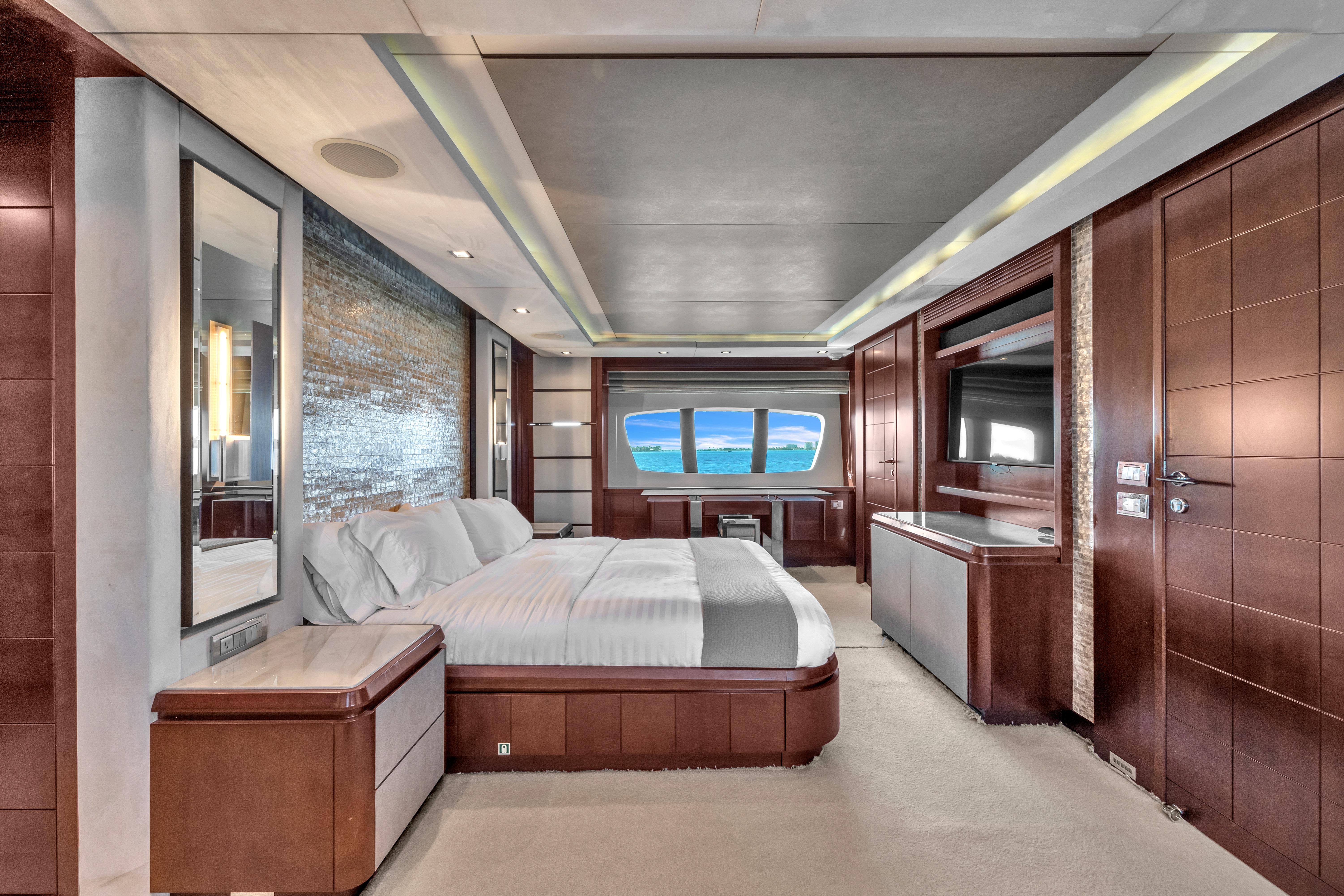 Luxurious bedroom interior of 2010 Azimut 95 yacht with ocean view through large windows.