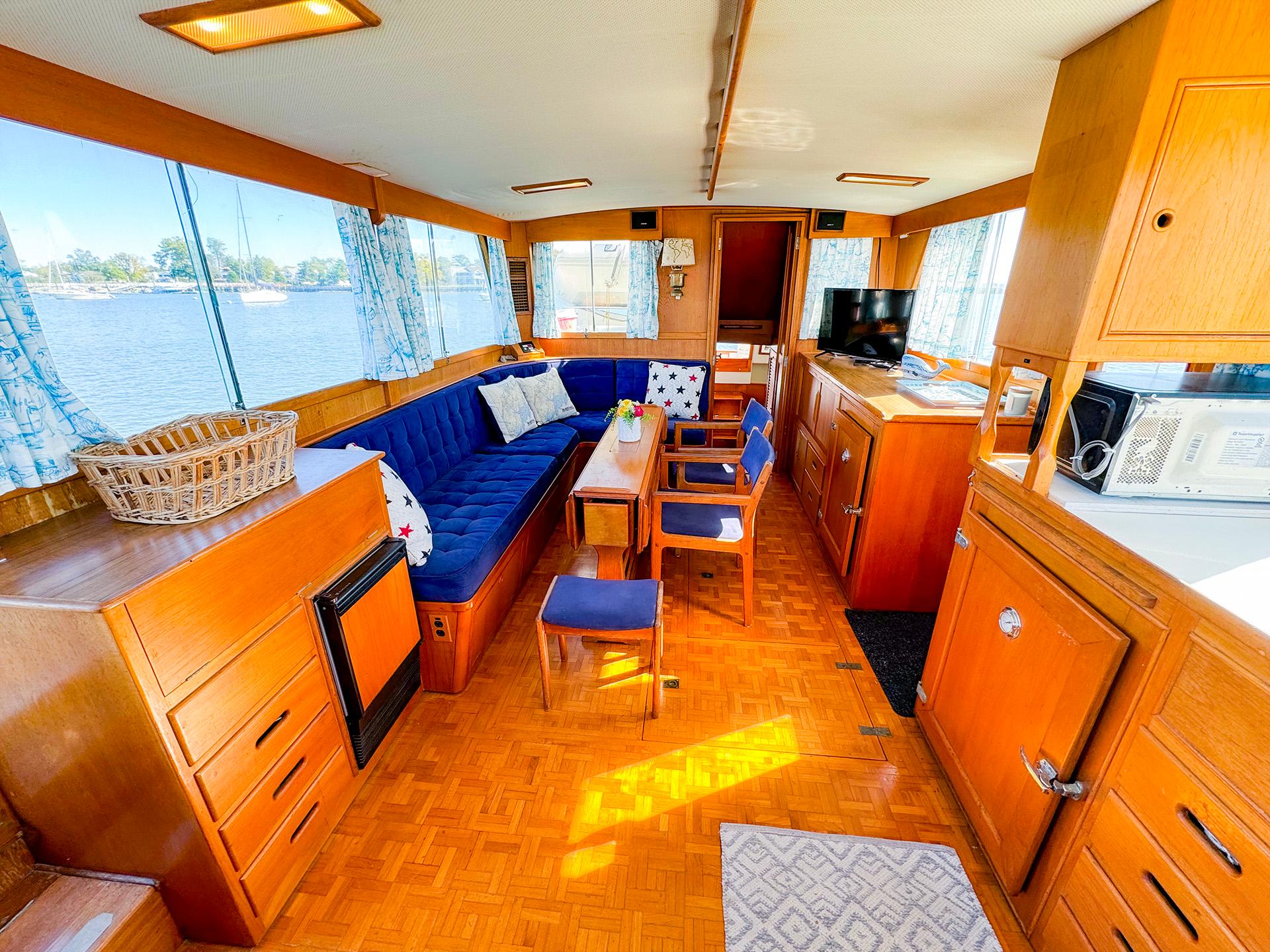 Interior of 1988 Grand Banks 42 Classic yacht with wood finish and blue seating.