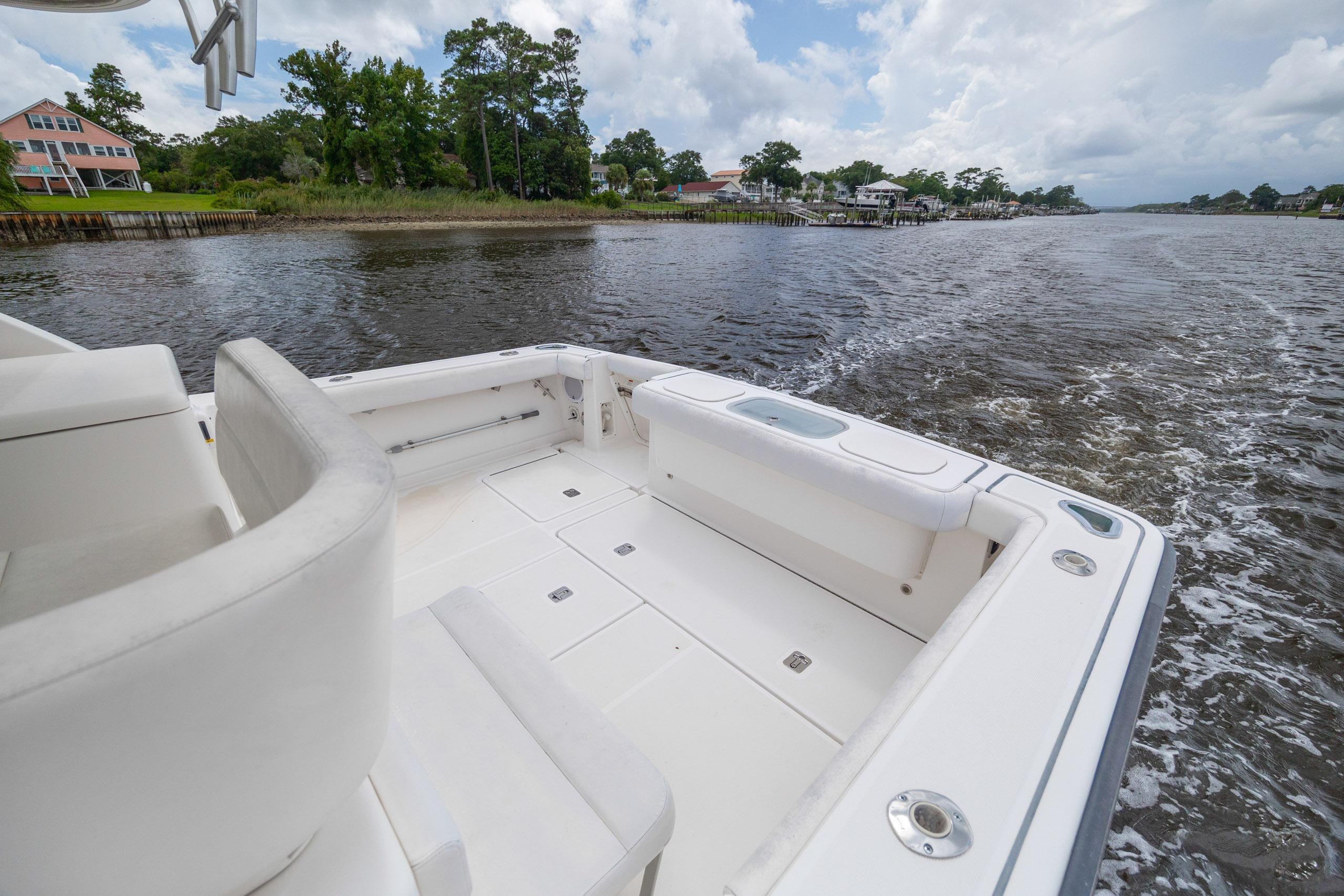 2004 Tiara Yachts 3200 Open cruising on a scenic river with lush greenery.