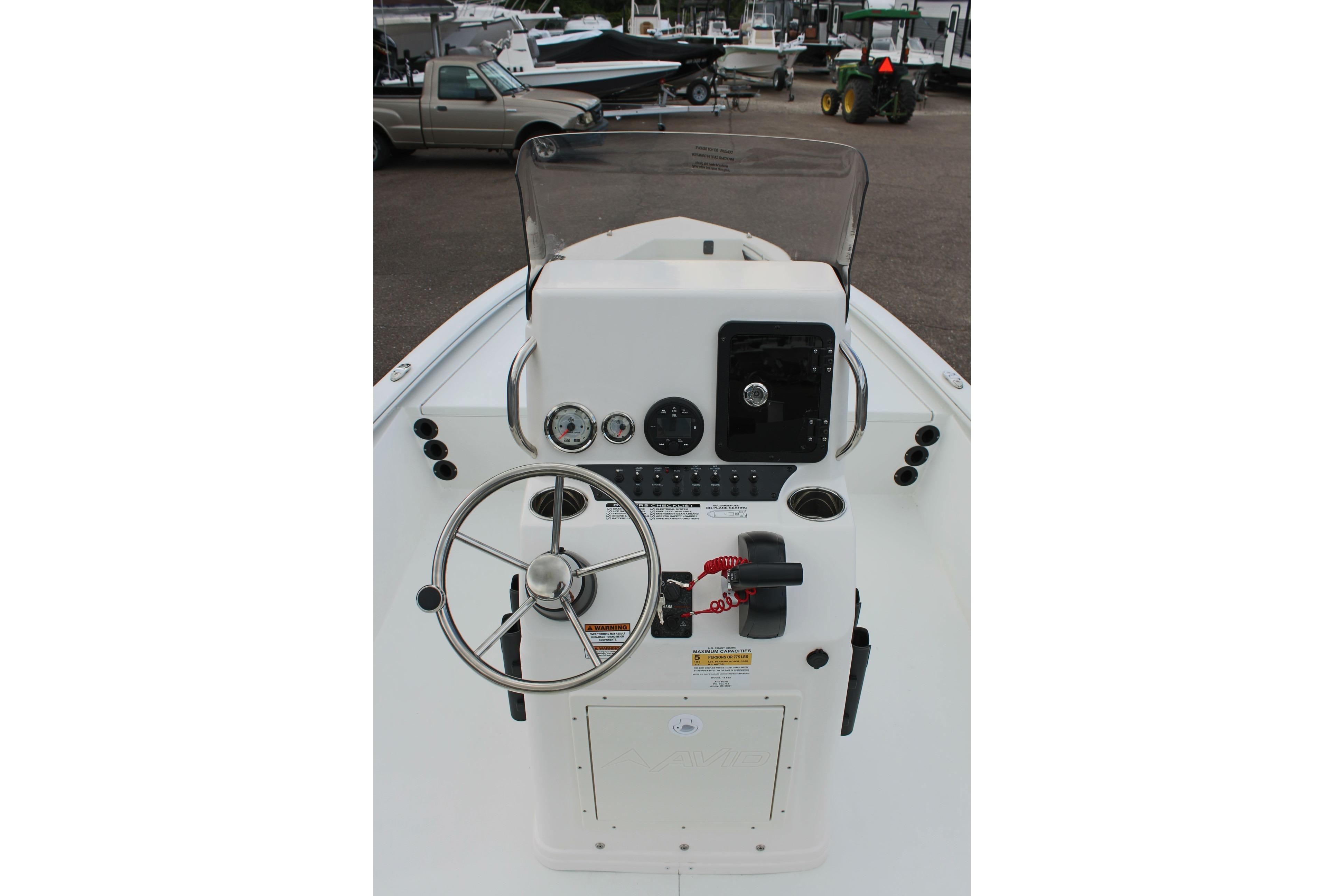 Center console of 2026 Avid 19 FSX boat with steering wheel and controls.