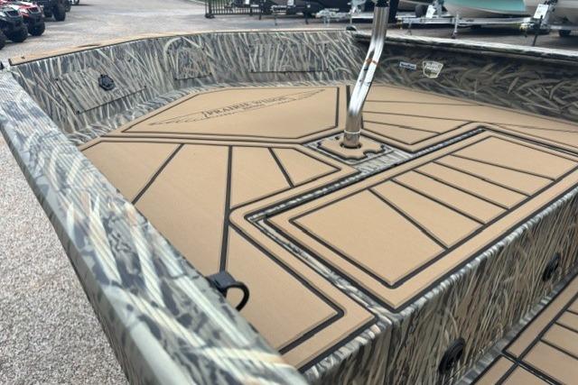2026 Tracker Grizzly 1650 T Prairie Wings Edition boat interior with camouflage design and padded flooring.
