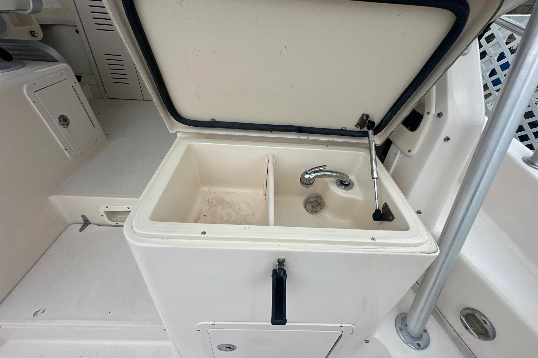2006 Grady-White Marlin 300 boat sink with open lid and faucet.