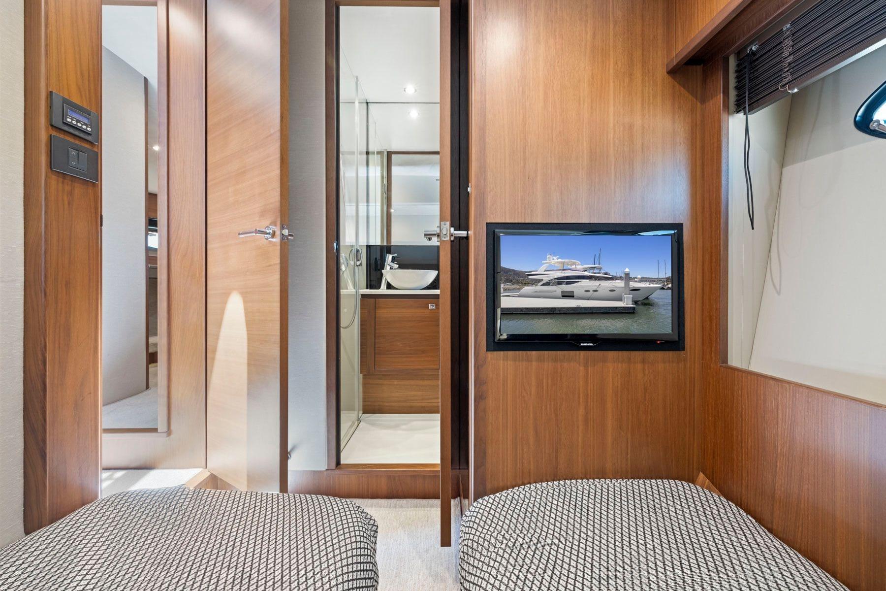 Interior of 2015 Princess 60 Flybridge Motor Yacht with modern wood paneling and TV display.