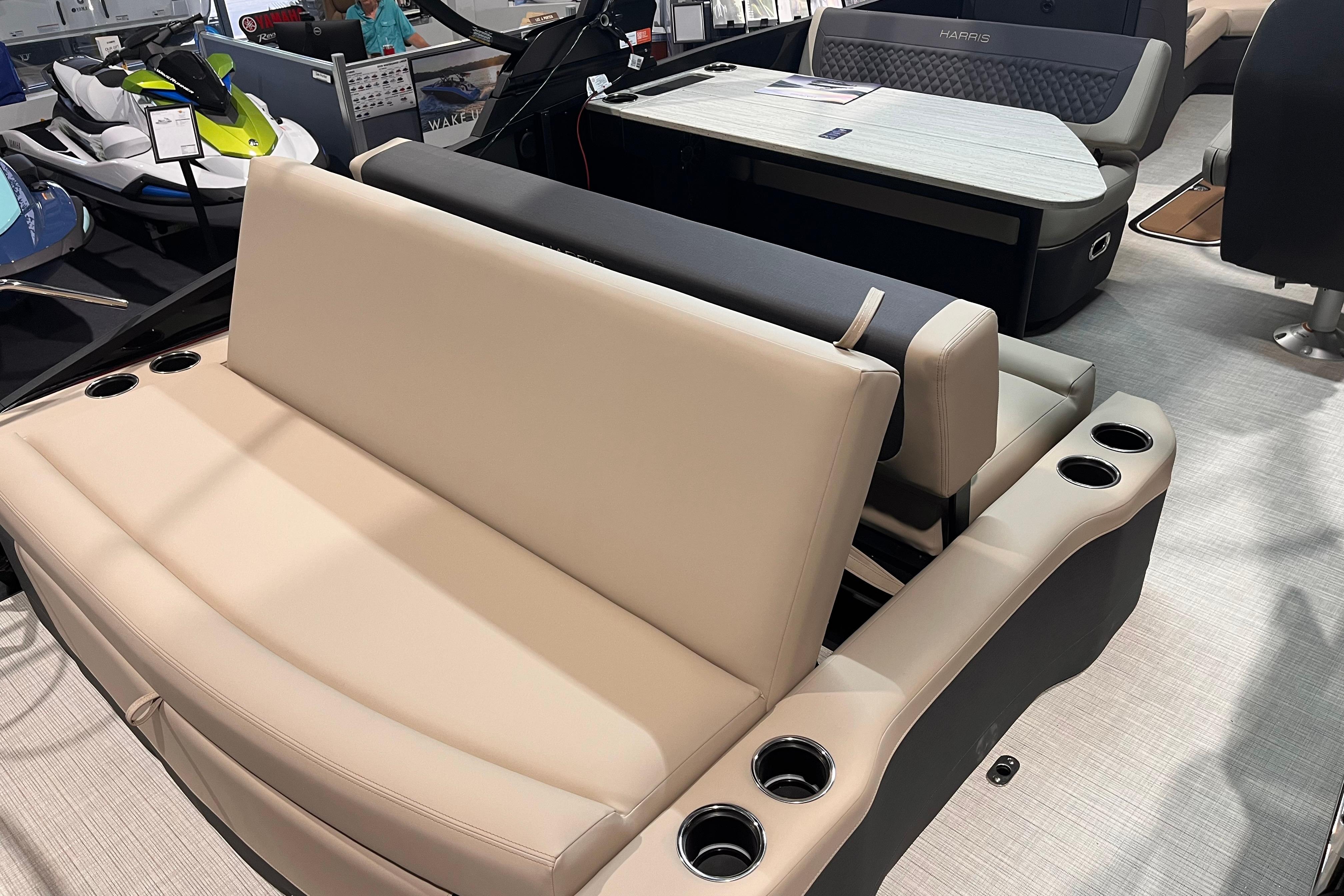 2026 Harris Sunliner 250 boat interior with beige seating and cup holders.